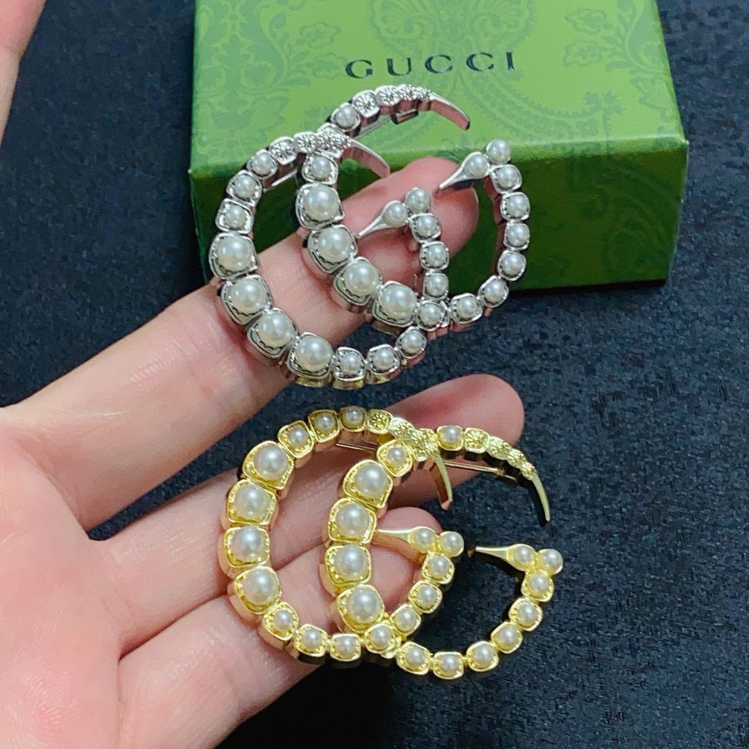 NO:590310,The new double G pearl gold and silver brooch at Gucci counter is the accessory that understands women best. Women who devote all their efforts to being themselves tend to cherish the meaning of brooches more. Ms. Gucci pins the brooch on her hat and tells the fashionable ladies who imitate her [Broches are very practical. They can be pinned on the collar of a suit, on a pocket, on a hat, on a belt or on an evening dress. Boutique jewelry, gucci, gucci, business suit, brooch, breastpin, hats19860909古驰Gucci专柜新款双G珍珠金银胸针,是最懂女人的饰物.那些倾注了全部心血去做自己的女人,往往更珍惜胸针的意义.古驰女士把胸针别在帽子上,并告诉那些模仿她的时髦女士们[胸针可是非常实用,它可以别在西装领上、口袋上、帽子上、腰带上或者是晚礼服上,饰品精品,gucci,gucci,business suit,brooch，breastpin,hats,Jewelry