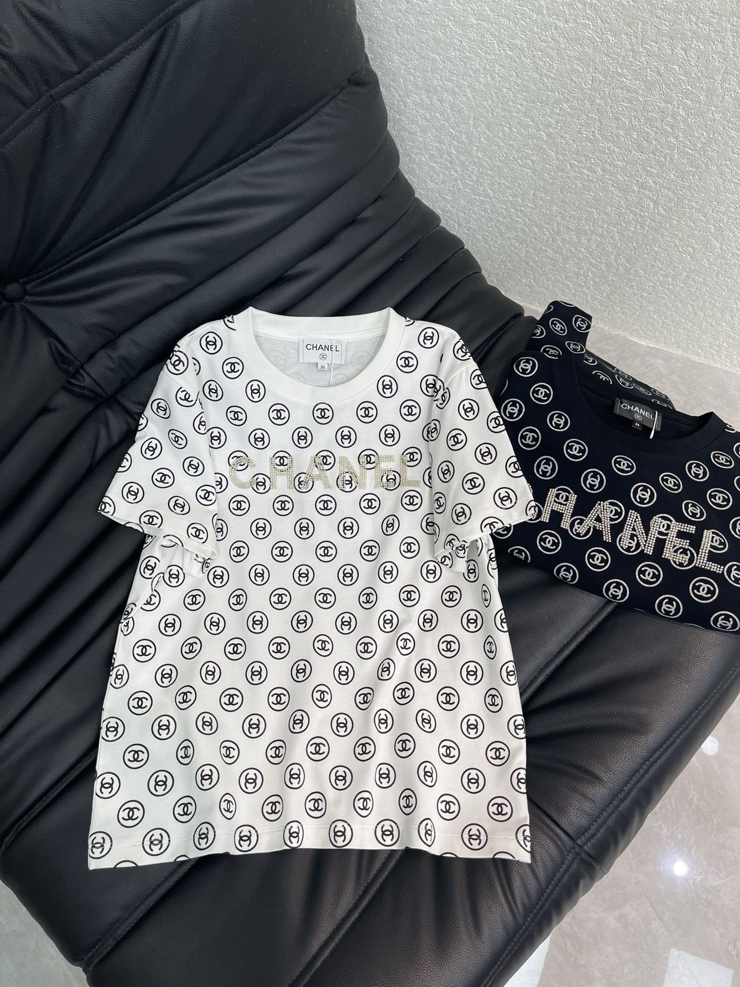 NO:605493,Chane*26 early spring new round neck printed beaded short-sleeved T-shirt. Customized YB twill cotton material, fine texture, stretchy and comfortable, regular round neck short-sleeved cut, embellished with diamond letter logo in the middle of the chest, double C element printing all over the body, double echo to highlight the brand style, black and white contrast embellishment makes it more refreshing, and it is stylish when worn alone. SML,,chanel,T-shirt,tees,t-shirt,alexander wang19860909Chane*26早春新款圆领印花订珠短袖T恤.定制YB斜纹全棉材质,质感细腻,弹力舒适,常规圆领短袖裁剪,胸口居中位置点缀烫钻字母徽标,通体满印双C元素印花,双重呼应凸显品牌格调,黑白撞色点缀更显清爽,单穿内搭都出彩时髦.SML,,chanel,T-shirt,tees，t-shirt,alexander wang,Women's clothing