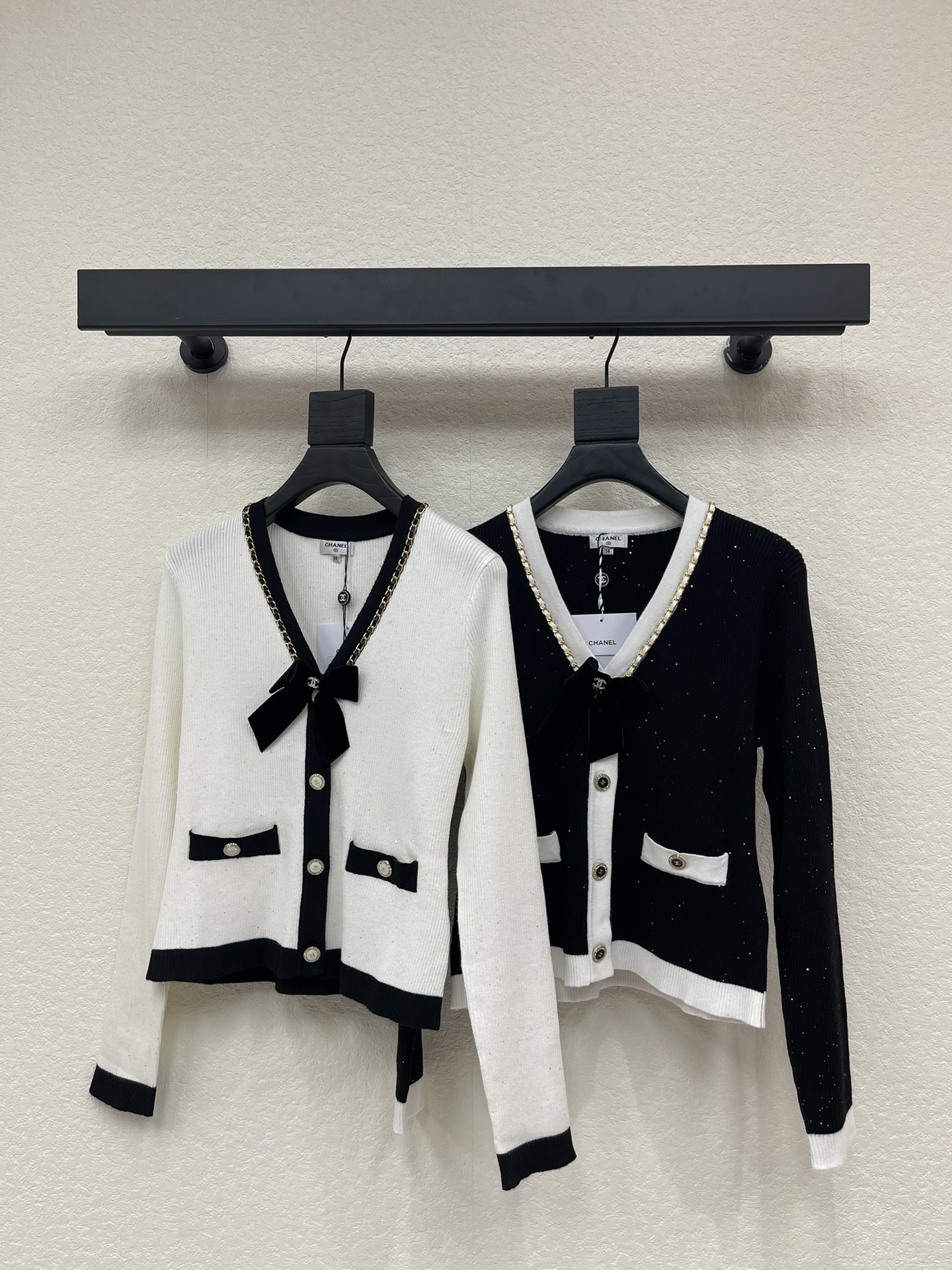 NO:605476,Chane*25 new autumn and winter black and white bow knitted cardigan. Customized YB wool yarn weaving, glossy texture, soft and skin-friendly, V-neck knitted cardigan style, delicate and soft flat stitch processing, relaxed texture without losing fashion sense, whole body hemming with black and white contrasting colors, ready-to-wear multiple pockets  The upper edge echoes, and Chanel's iconic chain is added to the neckline, combined with a bow and double C letter logo, showing a playful and age-reducing style. It is elegant and elegant, and is the first choice for daily wear. The black model has a shiny background that is more prominent. SML,,chanel,chanel,alexander  wang19860909Chane*25秋冬新款黑白蝴蝶结针织开衫.定制YB羊毛纱线织造,质感光泽,柔软亲肤,V领针织开衫版型,细腻柔软平针工艺处理,肌理松弛不失时尚感,通体包边以黑白撞色处理,成衣多口袋上缘呼应,领口增加香家标志性链条,配合蝴蝶结和双C字母徽标,展现俏皮减龄风格,气质大方,日常穿搭首选,黑色款底色亮闪更突出.SML,,chanel,chanel,alexander wang,Women's clothing