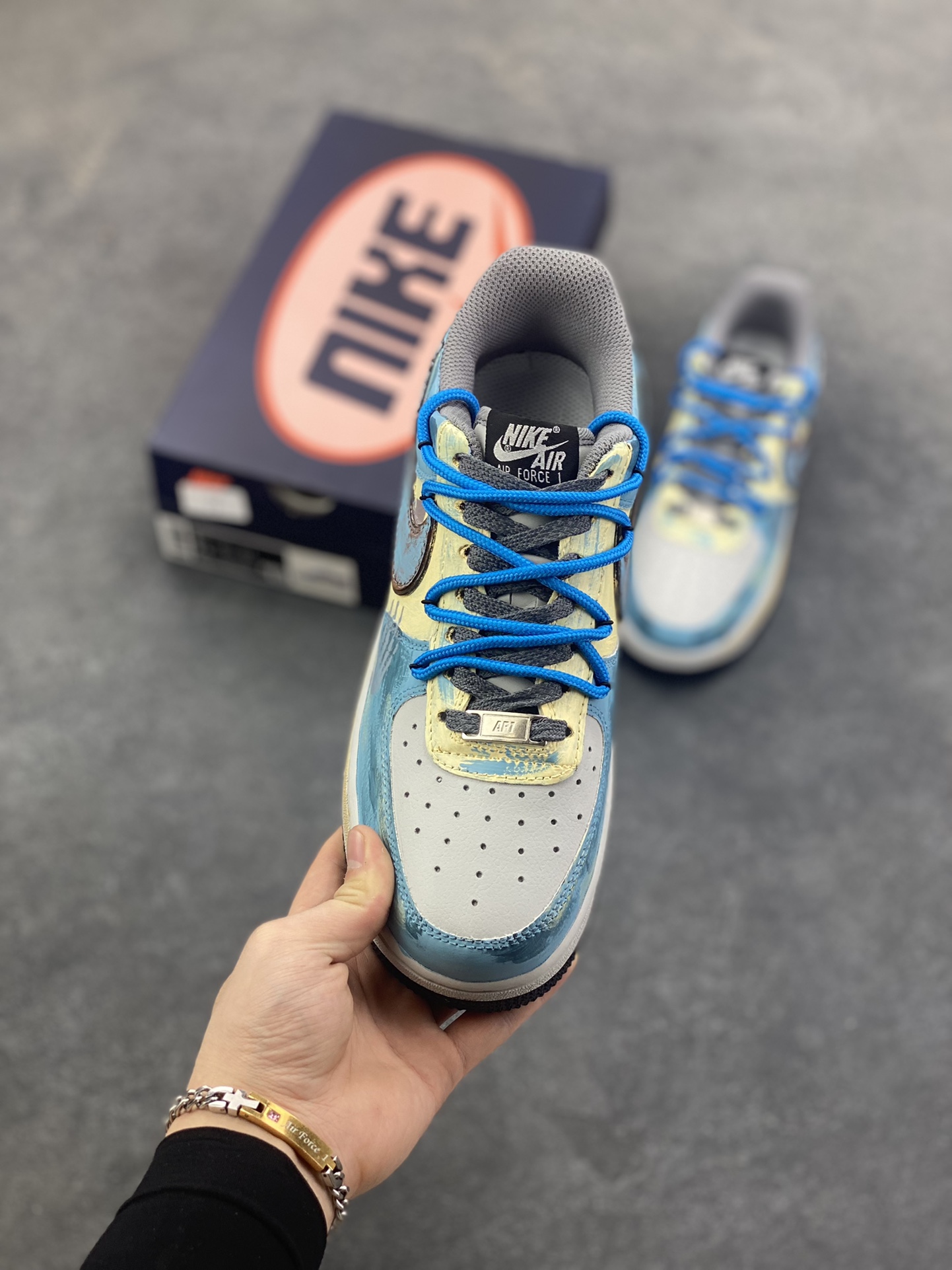 图片[2]-手绘涂鸦“雾蓝英雄”Nike Air Force 1 “Mist Blue Hero”空军一号定制板鞋 鞋身裹着一层雾感蓝灰的晕染，像清晨街景被薄雾浸软的色调，做旧肌理里藏着随性的泼墨痕迹，自带慵懒的复古滤镜；亮眼的蓝色绳状鞋带是点睛之笔，软乎乎的绳结打破了鞋身的朦胧感，添了几分街头的跳脱劲儿。鞋侧的“THE HERO”涂鸦最是灵魂——手写字体混着随性的线条，像某个少年在旧墙面上随手写下的英雄梦 货号：ZG0088-228 尺码：36 36.5 37.5 38 38.5 39 40 40.5 41 42 42.5 43 44 44.5 45-选品中心