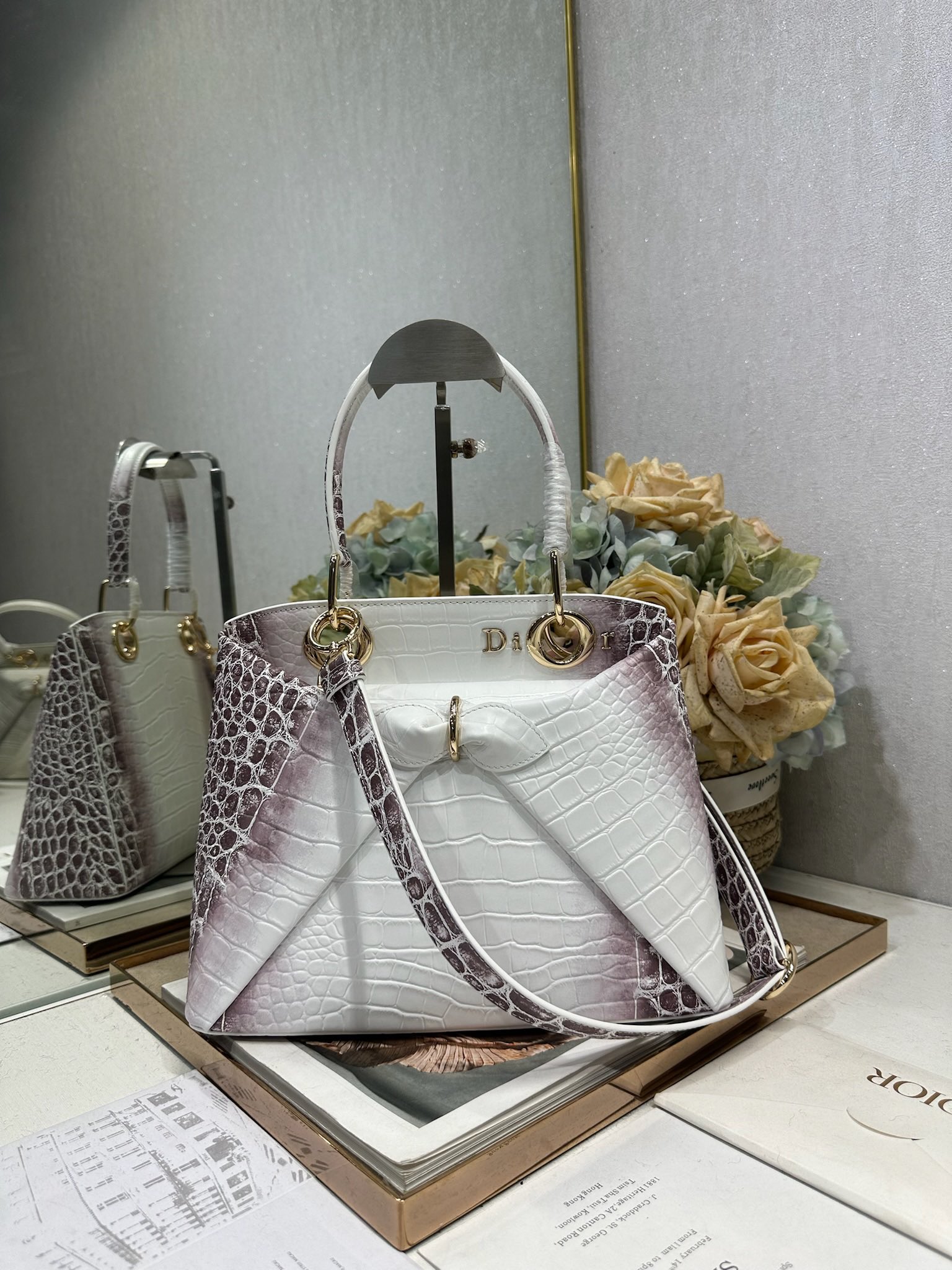 NO:771006,Dior 2026 spring and summer new product #Bowknot Handbag# Crocodile pattern 'Himalaya White' has a newly designed silhouette and shape, rich color matching, and is suitable for many people!  Just the right balance between exaggeration and elegance!  Its design is inspired by the Cigale dress designed by Mr. Dior ~ the three-dimensional trapezoidal body + single handle, the shape has an elegant and majestic tone. The appearance of the bag is relatively low-key, with almost no obvious big logo. Looking closer, it turns out that Anderson has integrated the Dior letter logo and the round hole of the bag handle. The bag is recognizable, and it is not ostentatious at all. The whole bag exudes a sense of quiet luxury!  It is worth mentioning that this bag is also equipped with a long leather shoulder strap. Especially when traveling, you can put on the long shoulder strap, which not only frees your hands, but also makes people relaxed and casual~ Model 0737 Size 28*10*22 (length*width*height), Dior, dior, dior19860909Dior 2026 春夏新品#蝴蝶结手提包#鳄鱼纹「喜马拉雅白」 新设计的轮廓与造型,配色 丰富,适配多人！在夸张与优雅之间恰到好处！它的设计灵感源于迪奥先生设计的 Cigale礼服~立体的梯形包身+单手柄,造型自带优雅大气的腔调.包包的外观比较低调,几乎没有什么明显的大Logo.离近点再看,才发现原来Anderson把Dior字母Logo和包包提手的圆孔融合到了一起. 包包既有辨识度,也完全不是张扬挂的,整体散发着那种不动声色的高级感！值得一提的是,这款包还搭配了一条皮质长肩带.尤其出门旅行的时候就可以换上长肩带,既解放了双手,还衬得人轻松又随性~ 型号0737 尺寸28*10*22（长*宽*高）,迪奥,dior,dior,Bag