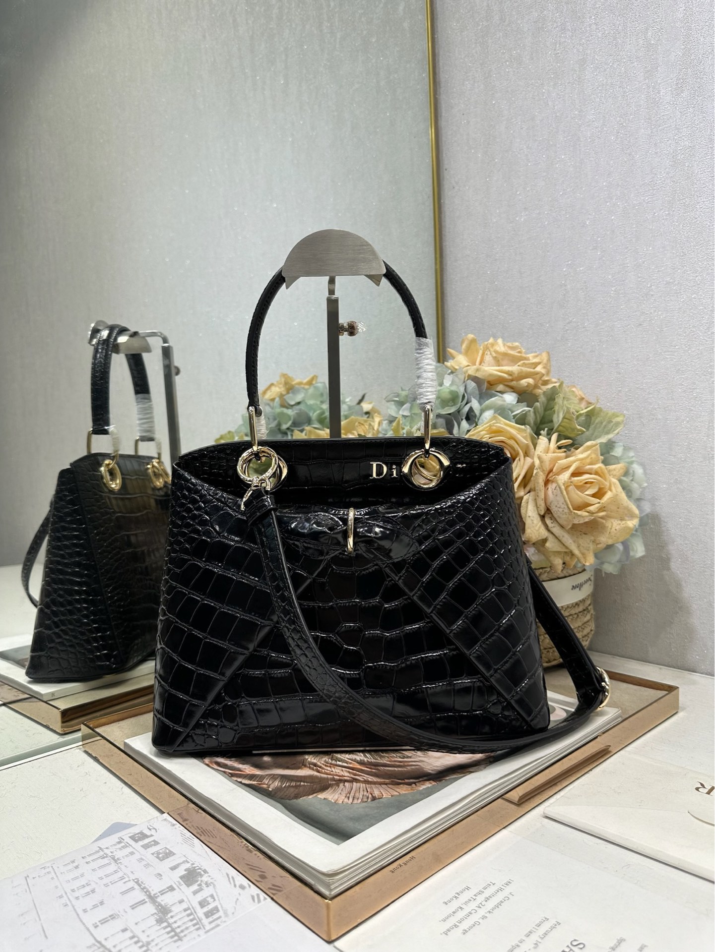 NO:771012,Dior 2026 spring and summer new product #Bowknot Handbag# Crocodile pattern 'black' has a newly designed outline and shape, rich color matching, and is suitable for many people!  Just the right balance between exaggeration and elegance!  Its design is inspired by the Cigale dress designed by Mr. Dior ~ the three-dimensional trapezoidal body + single handle, the shape has an elegant and majestic tone. The appearance of the bag is relatively low-key, with almost no obvious big logo. Looking closer, it turns out that Anderson has integrated the Dior letter logo and the round hole of the bag handle. The bag is recognizable, and it is not ostentatious at all. The whole bag exudes a sense of quiet luxury!  It is worth mentioning that this bag is also equipped with a long leather shoulder strap. Especially when traveling, you can put on the long shoulder strap, which not only frees your hands, but also makes people relaxed and casual~ Model 0737 Size 28*10*22 (length*width*height), Dior, dior, dior19860909Dior 2026 春夏新品#蝴蝶结手提包#鳄鱼纹「黑色」 新设计的轮廓与造型,配色 丰富,适配多人！在夸张与优雅之间恰到好处！它的设计灵感源于迪奥先生设计的 Cigale礼服~立体的梯形包身+单手柄,造型自带优雅大气的腔调.包包的外观比较低调,几乎没有什么明显的大Logo.离近点再看,才发现原来Anderson把Dior字母Logo和包包提手的圆孔融合到了一起. 包包既有辨识度,也完全不是张扬挂的,整体散发着那种不动声色的高级感！值得一提的是,这款包还搭配了一条皮质长肩带.尤其出门旅行的时候就可以换上长肩带,既解放了双手,还衬得人轻松又随性~ 型号0737 尺寸28*10*22（长*宽*高）,迪奥,dior,dior,Bag