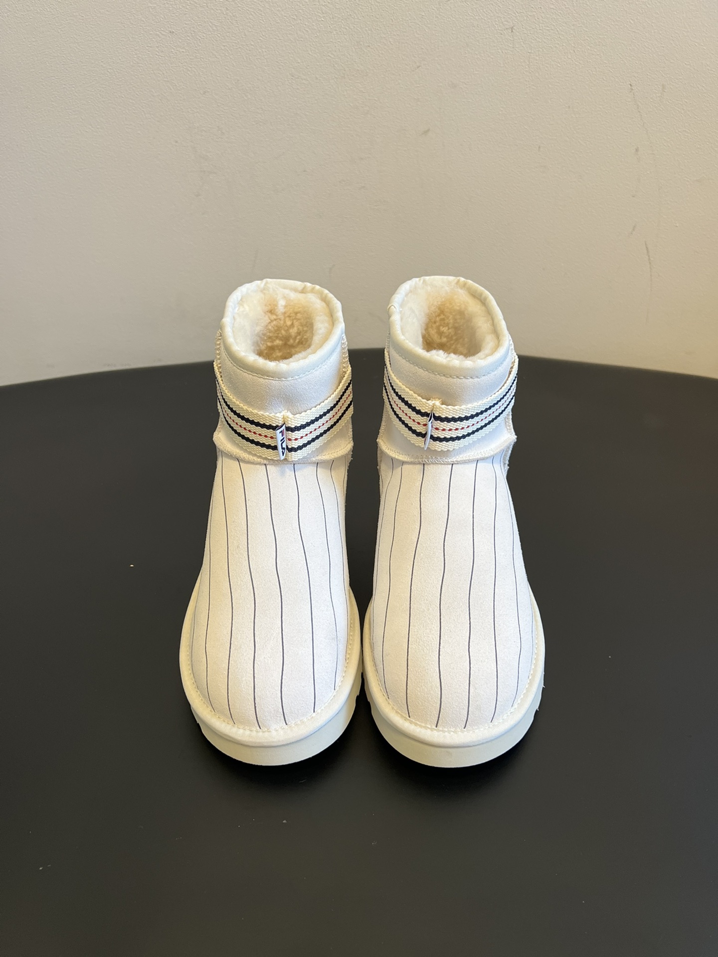 NO:628831,The top-quality Ug* co-branded series of snow boots are based on UGG classic short boots and incorporate iconic elements of different brands, such as stripes, checkerboards, sports brand logos, etc., to create the visual effect of a trendy co-branded model with a younger style. The interior is made of the brand's iconic sheepskin material, which is soft and skin-friendly and has strong heat-locking properties. It is the main shoe to keep out the cold in autumn and winter. The shoe shape is loose and does not squeeze the feet, making it comfortable to wear for a long time.  The uppers are mostly made of suede or suede material, which has a soft texture and is easy to care for. The soles are lightweight rubber soles, which are non-slip and wear-resistant while reducing the burden on the feet and making walking easier. They can be paired with casual trousers to create a street trend, or they can be paired with skirts to create a 'sweet and warm mix' style. Different colors and elements are suitable for a variety of daily wear scenarios. The upper is cow suede and the lining is wool. The outsole is original molded outsole and has a height of 4cm.  : 35-40 yards (customized sizes 40 are non-refundable), snow boots, boots, skirts, sheepskin, chamois leather19860909顶级品质 Ug*联名款系列雪地靴短靴 以UGG经典短靴为基础,融入不同品牌的标志性元素,比如条纹、棋盘格、运动品牌Logo等,打造出潮流联名款的视觉效果,风格更年轻个性.内里采用品牌标志性的羊皮毛材质,柔软亲肤且锁温性强,是秋冬御寒的主力鞋款,鞋型宽松不挤脚,长时间穿着也舒适. 鞋面多用麂皮或绒面材质,质感柔和且易打理,鞋底是轻质橡胶底,防滑耐磨的同时减轻脚部负担,行走更轻便.既能搭配休闲裤装营造街头潮感,也能配裙装打造“甜暖混搭”风,不同配色和元素适配多种日常穿搭场景. 鞋面牛反绒 内里羊毛 大底原版开模大底 增高4cm size :35-40码（40码定制不退换）,雪地靴,boots,skirts,sheepskin,chamois leather,Women's Shoes