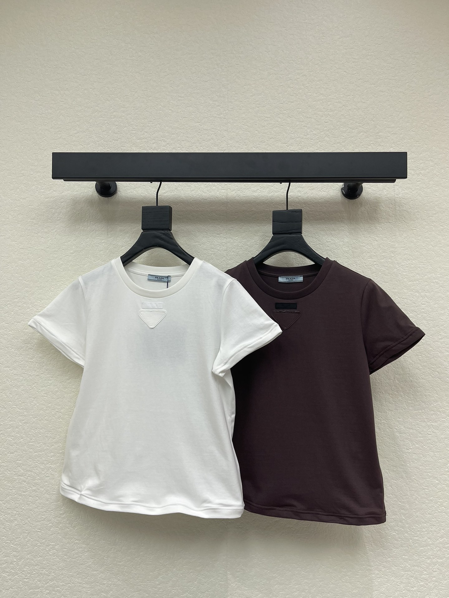 NO:610156,Prad*26 early spring new steel ring short-sleeved triangle logo short-sleeved T-shirt. Customized YB native cotton material, breathable and comfortable, full of texture, regular short-sleeved T-shirt cut to highlight the brand style, made of heavyweight pure cotton, slightly stretchy, showing a slimming visual effect, self-made  The triangular patch in the center of the chest restores the classic logo shape, and matches the letter brand logo pattern. The regular arrangement enriches the visual effect. The hem is processed with steel rings and can be shaped at will to create a casual and fashionable personality style. The brand's high-end design sense is full, and it is stylish when worn alone. SML  AA,,prada,T-shirt,tees,t-shirt,alexander wang19860909Prad*26早春新款钢圈短袖三角徽标短袖T恤.定制YB原生全棉材质,透气舒适,质感十足,常规短袖T恤裁剪,凸显品牌格调,采用克重纯棉制成,略带有弹力,呈现显瘦视觉效果,自胸口居中以三角贴布还原经典徽标造型,配合字母品牌徽标图案,规则排列丰富视觉效果,下摆钢圈处理,随意塑形,打造休闲时髦的个性风格,品牌高级设计感拉满,单穿内搭都出彩时髦.SML AA,,prada,T-shirt,tees，t-shirt,alexander wang,Women's clothing