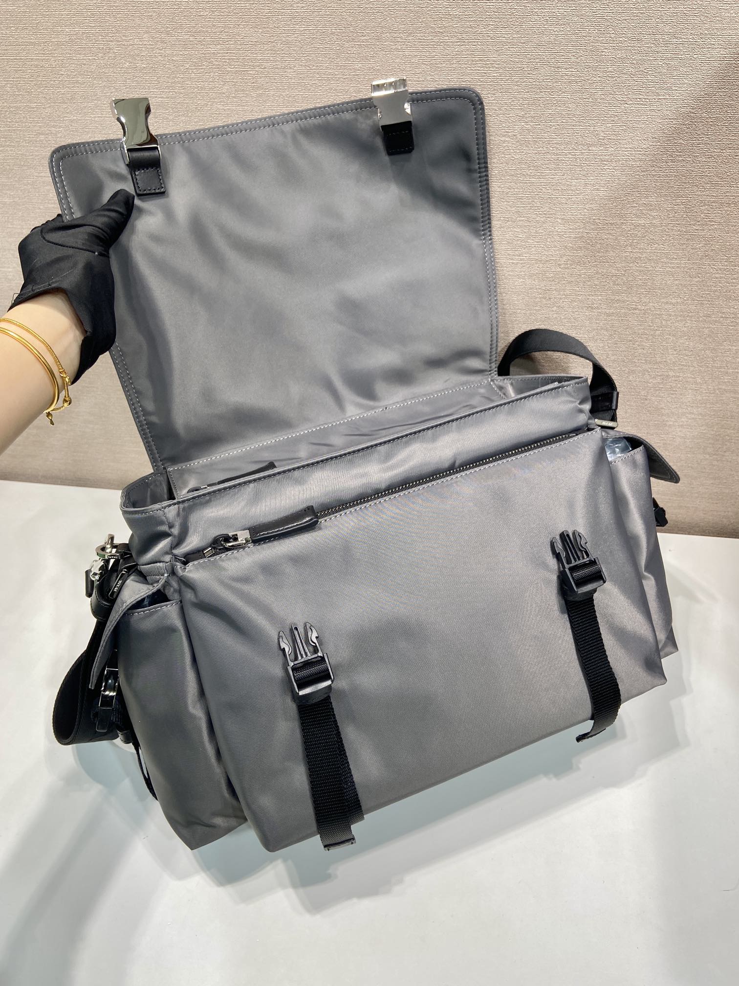 💰660🎉新品邮包🎉2VD082水银色🎉🎉
这款Explore手袋完美融合了高雅与功能性，拥有多口袋的柔和线条轮廓。翻盖设计，专为城市探索和户外冒险而设计，配有肩带和可拆卸提手，可多种方式携带。再生尼龙与皮革的结合体现了设计的双重性，融合了技术细节与精致元素。容量空间大，又是一款永久不过时爆款，赶紧入手吧🎉🎉
长42x高22x底20cm🎉🎉🎉💰💰💰
