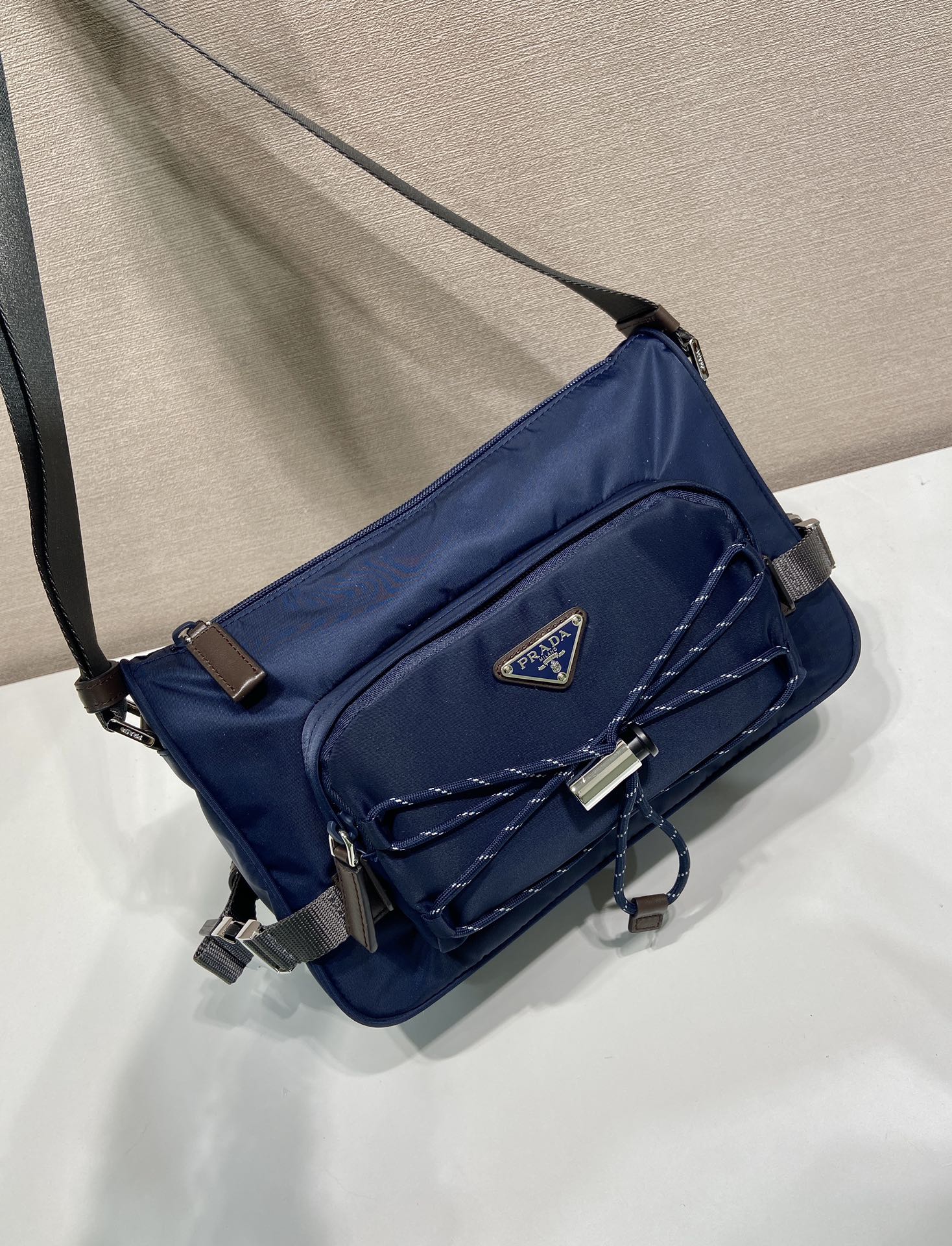 💰470🎉新款邮差包🎉2VH192新品🎉🎉
这款单肩包兼顾了功能性和装饰性，融合了都市风格和户外元素。Re-Nylon包袋设计轻巧紧凑，融入了丰富的技术细节，赋予配饰现代的运动风格。带可调节技术软线，可调编织尼龙长肩带，拉链封口。容量空间大，又是一款永久不过时爆款🎉🎉
长28x高17.5x底10cm🎉🎉🎉
