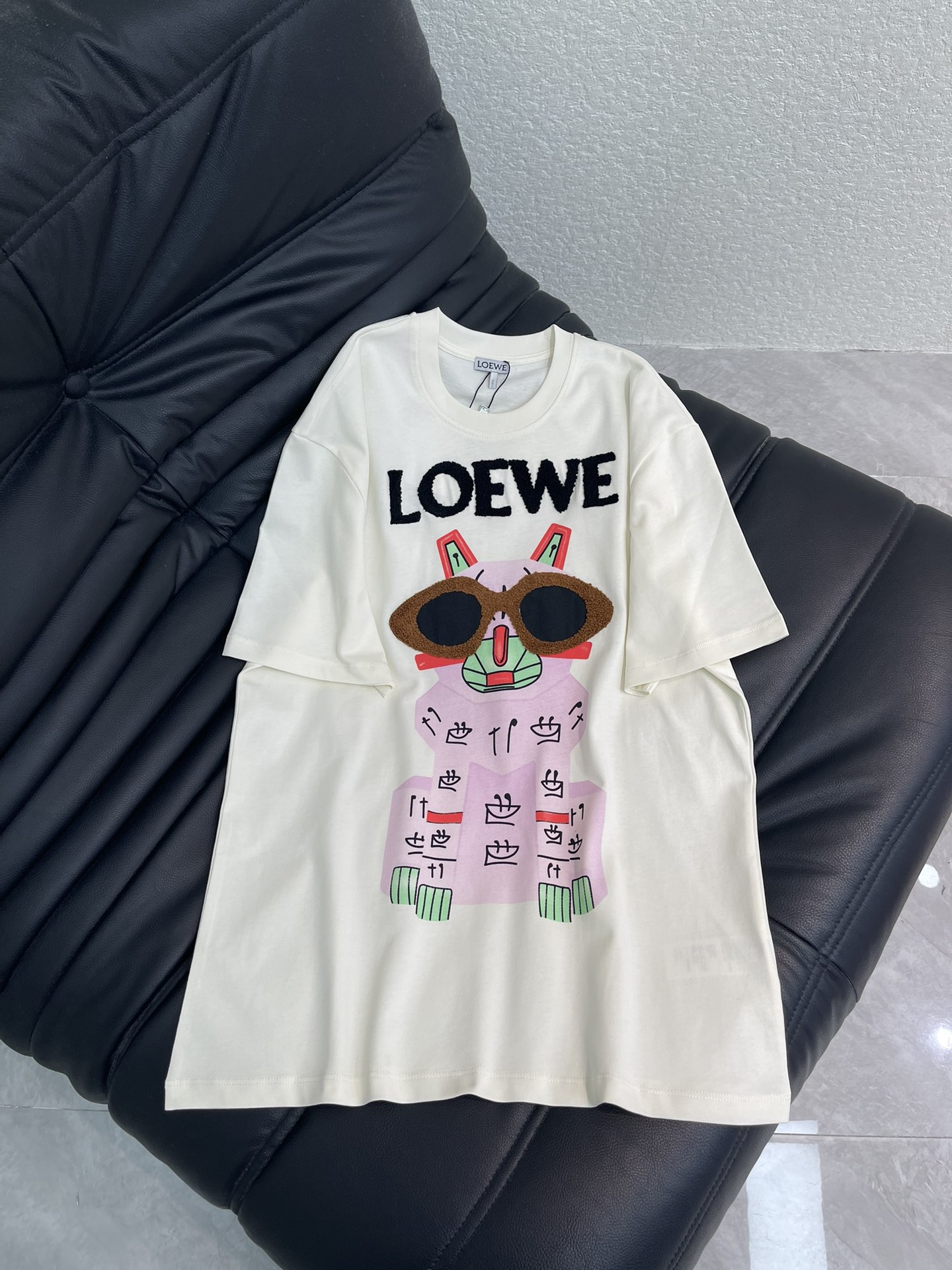 NO:656194,Loew*26 early spring new round neck cartoon printed short-sleeved T-shirt. Customized YB twill cotton material, fine texture, comfortable and breathable, regular short-sleeved cutting, highlighting the brand style, made of cotton material, slightly stretchy, showing a slimming visual effect, the chest is restored with printing technology  Cartoon kitten pattern on the chest, plush processing to shape the letter logo glasses pattern, adding three-dimensional artistic temperament, fashionable and casual, stylish and stylish when worn alone or worn inside. SML,, loewe, T-shirt, tees, t-shirt, alexander  wang19860909Loew*26早春新款圆领卡通印花短袖T恤.定制YB斜纹全棉材质,质感细腻,舒适透气,常规短袖裁剪,凸显品牌格调,采用全棉材质,略带有弹力,呈现显瘦视觉效果,胸前以印花工艺还原胸前卡通小猫图案,毛绒处理塑造字母徽标眼镜图案,增添立体艺术气质,时髦休闲,单穿内搭都出彩时髦.SML,,loewe,T-shirt,tees，t-shirt,alexander wang,Women's clothing