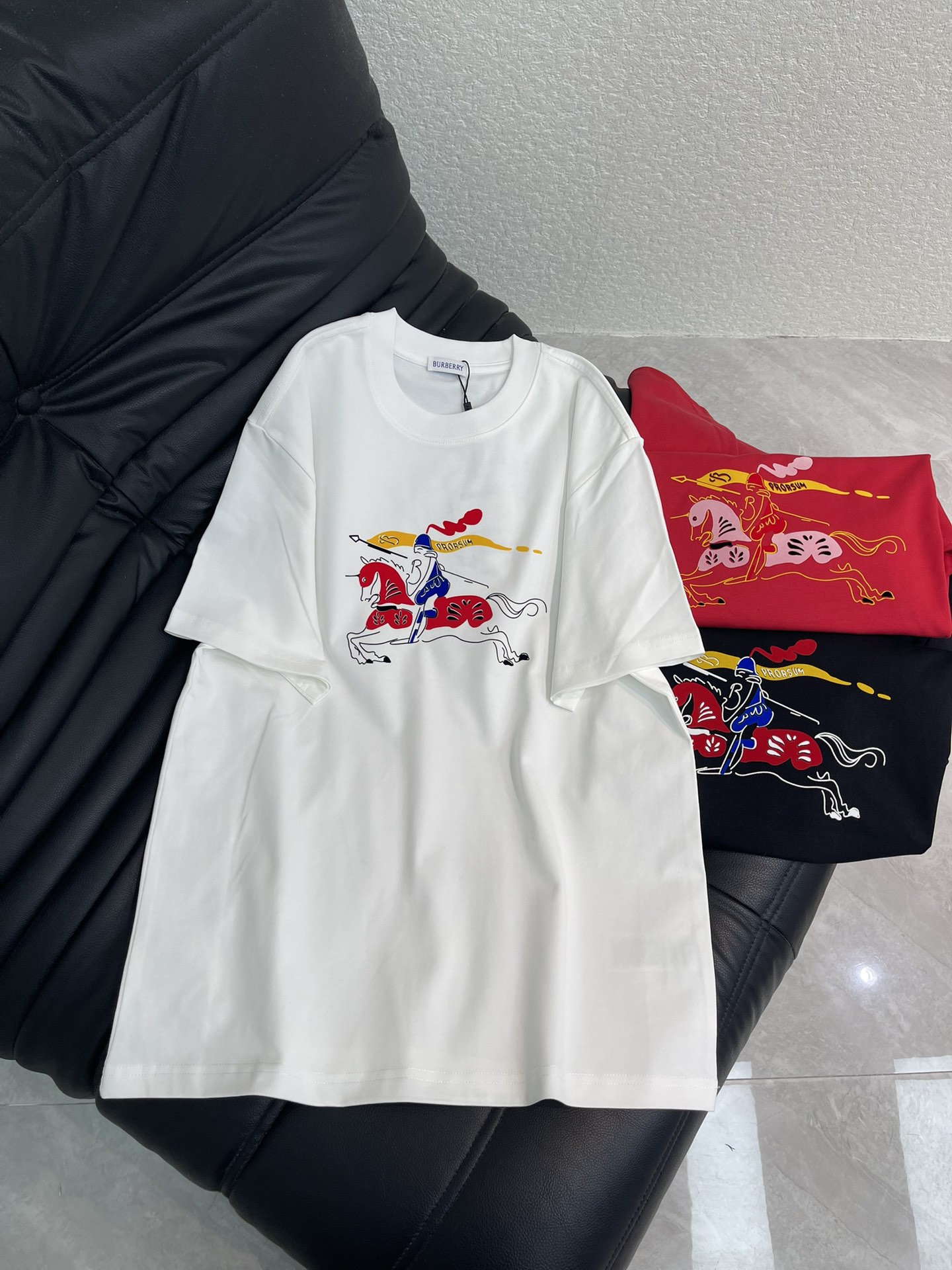NO:656951,Burberry*26 new spring and summer new Year of the Horse limited-edition short-sleeved T-shirt. Main color + cartoon galloping horse print, blue knight and red war horse, with the word 'PRORSUM' on the flag, the design is full of festive atmosphere!  High-quality 280g pure cotton fabric, soft and breathable, super comfortable to wear. Loose round neck design, versatile and adaptable to any figure, easy to control various styles. The limited edition for the Year of the Horse is highly collectible, the same style for men and women. Color white, red, black Size S-XL, burberry, T-shirt, tees, t-shirt, alexander wang19860909Burberry*26春夏新款马年限定短袖T恤.主色调+卡通奔马印花,蓝色骑士红色战马,旗帜上有'PRORSUM'字样,设计感满满节日氛围感拉满！高品质280g纯棉面料,柔软透气,穿着超舒适.宽松圆领设计,百搭不挑身材,轻松驾驭各种风格.马年限定款超有收藏价值,男女同款. 颜色白色、红色、黑色 码数S-XL,,burberry,T-shirt,tees，t-shirt,alexander wang,Women's clothing