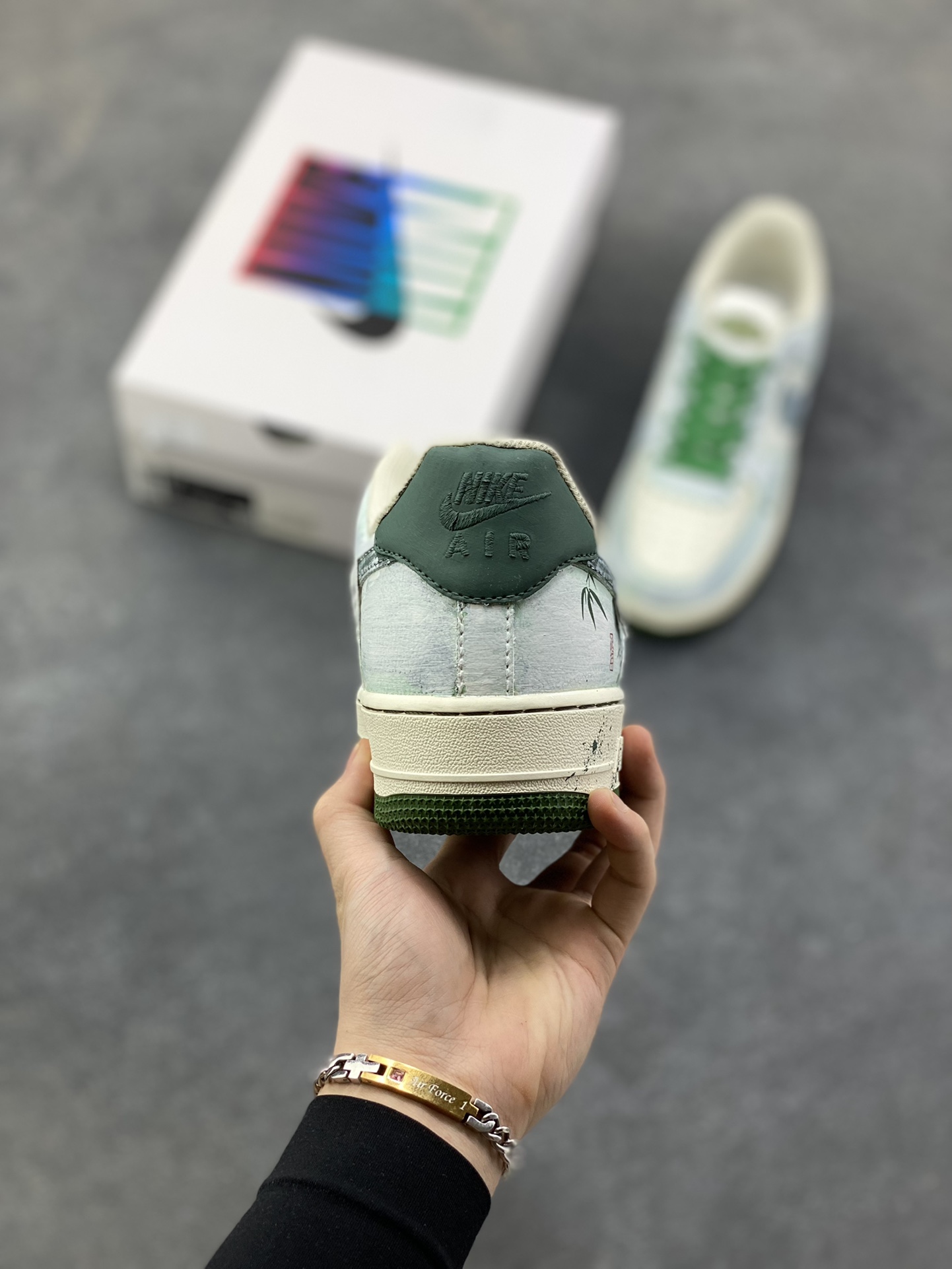 图片[4]-手绘涂鸦“青竹墨韵”Nike Air Force 1 “Bamboo in Ink Wash”空军一号定制板鞋 这双「青竹墨韵」便成了东方美学的行走载体。鞋身以浅青瓷色为底，晕染开水墨质感的竹枝纹理 ——Logo 被竹叶肌理包裹，鞋侧的竹影细节与墨色斑点呼应，搭配深竹绿鞋带与包边，恰似烟雨里的竹林意境,让街头鞋款晕染出 “宁可食无肉，不可居无竹” 的文人风骨 货号：FB1839-123 尺码： 36 36.5 37.5 38 38.5 39 40 40.5 41 42 42.5 43 44 44.5 45-选品中心