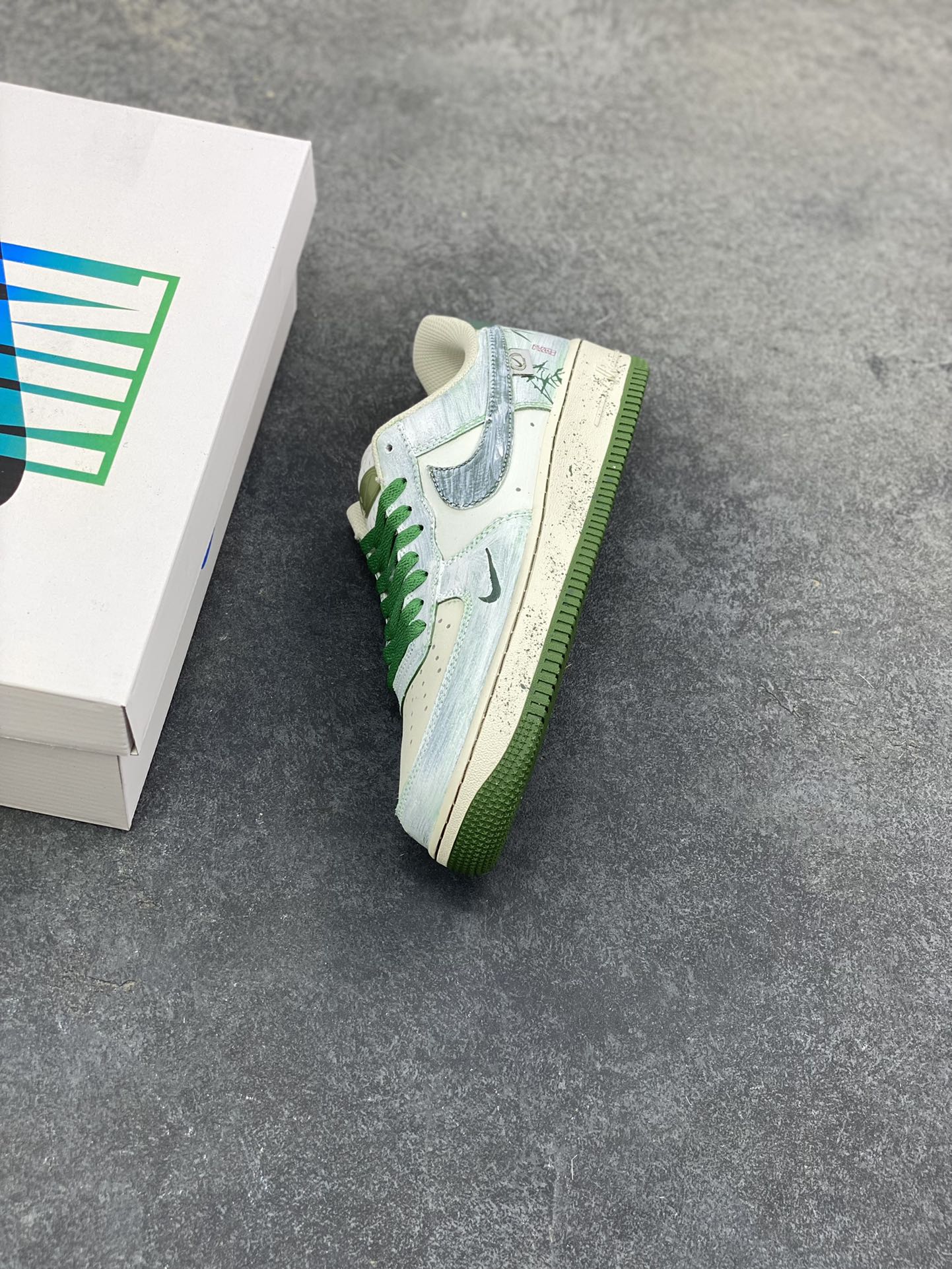 图片[7]-手绘涂鸦“青竹墨韵”Nike Air Force 1 “Bamboo in Ink Wash”空军一号定制板鞋 这双「青竹墨韵」便成了东方美学的行走载体。鞋身以浅青瓷色为底，晕染开水墨质感的竹枝纹理 ——Logo 被竹叶肌理包裹，鞋侧的竹影细节与墨色斑点呼应，搭配深竹绿鞋带与包边，恰似烟雨里的竹林意境,让街头鞋款晕染出 “宁可食无肉，不可居无竹” 的文人风骨 货号：FB1839-123 尺码： 36 36.5 37.5 38 38.5 39 40 40.5 41 42 42.5 43 44 44.5 45-选品中心