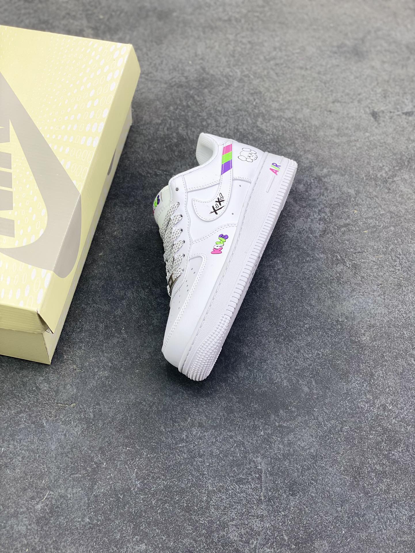 图片[7]-Nike Air Force 1 Low × KAWS联名款，直接把潮玩基因焊在鞋上了！ 纯白鞋身打底，撞色KAWS标志性“XX眼”Logo+彩色字母标识，甜酷感拉满，日常穿搭随便搭都能出片~鞋侧的拼色条纹+后跟小玩偶图案，细节里全是设计巧思，属于“上脚自带焦点”的款！货号XS1958-620，潮人鞋柜必蹲的联名款，这波颜值真的稳赢~-选品中心