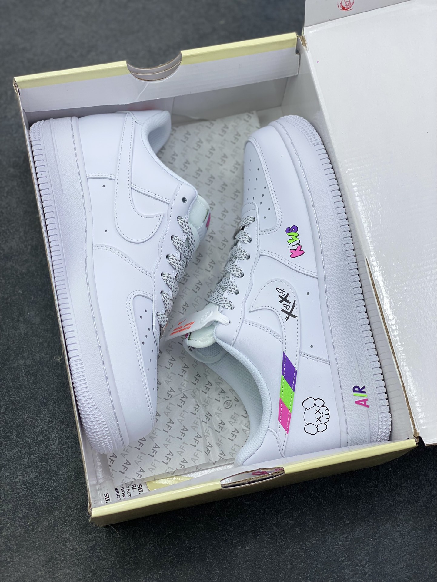 图片[9]-Nike Air Force 1 Low × KAWS联名款，直接把潮玩基因焊在鞋上了！ 纯白鞋身打底，撞色KAWS标志性“XX眼”Logo+彩色字母标识，甜酷感拉满，日常穿搭随便搭都能出片~鞋侧的拼色条纹+后跟小玩偶图案，细节里全是设计巧思，属于“上脚自带焦点”的款！货号XS1958-620，潮人鞋柜必蹲的联名款，这波颜值真的稳赢~-选品中心