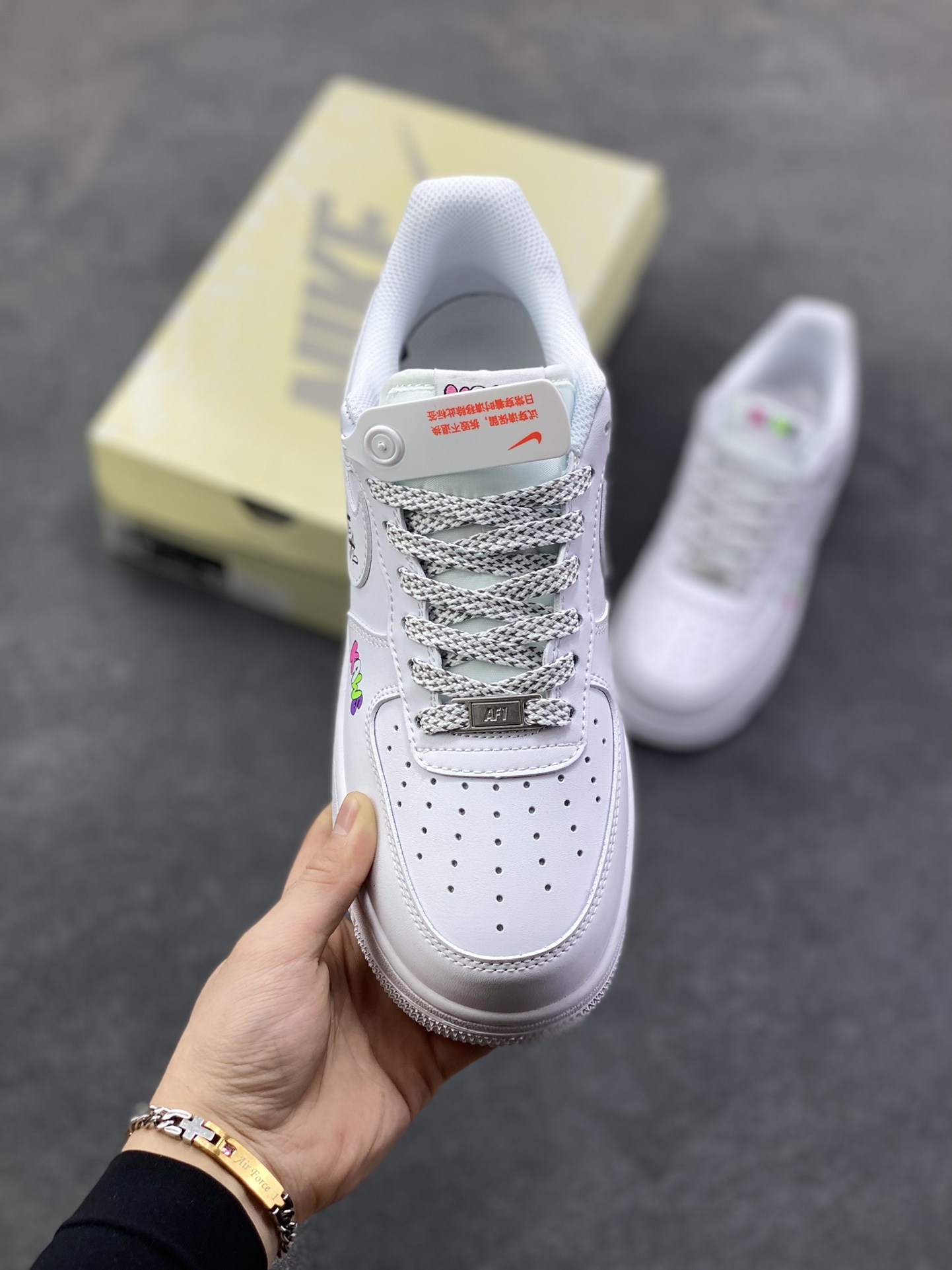 图片[2]-Nike Air Force 1 Low × KAWS联名款，直接把潮玩基因焊在鞋上了！ 纯白鞋身打底，撞色KAWS标志性“XX眼”Logo+彩色字母标识，甜酷感拉满，日常穿搭随便搭都能出片~鞋侧的拼色条纹+后跟小玩偶图案，细节里全是设计巧思，属于“上脚自带焦点”的款！货号XS1958-620，潮人鞋柜必蹲的联名款，这波颜值真的稳赢~-选品中心