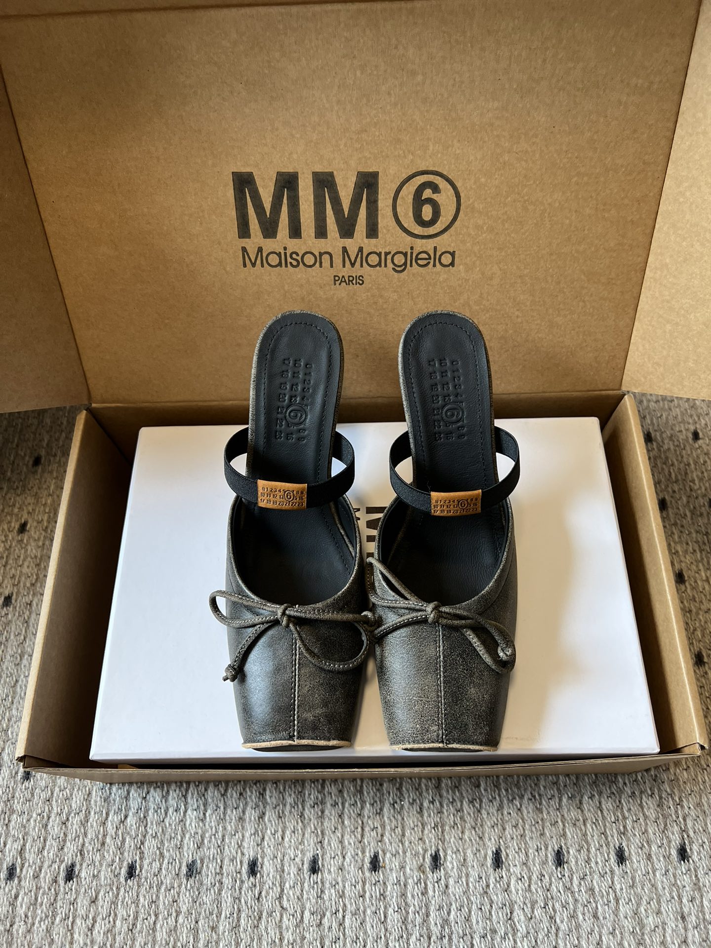 NO:653388,Maison Margiel* Square Toe Stretch Strap Ballet Shoes High Heels Sandals adopt the brand's signature sculptural silhouette that fits the shape of the foot. The upper is soft and smooth, taking into account both fit and design. The square toe + ballet elements are combined with the classic square toe design to create a modern feel. It is paired with the bow decoration on the upper to reconstruct the elegant outline of the ballet shoes. At the same time, it is made into a mules-back style, which is both casual and sophisticated.  There is the iconic white single-thread stitching on the heel, and the elastic band of the shoe body has the MM6 digital logo, which is the key to brand recognition. The empty mule slip structure simplifies the way of putting on and taking off, combining the softness of ballet shoes with the casualness of mule shoes. The upper is retro burst cowhide, the lining is silk sheepskin, the outsole is genuine leather, and the height is increased by 8cm.  margiela,sandals,high heels,slippers,cowhide,sheepskin,Leather soles19860909Maison Margiel*方头弹力带芭蕾鞋高跟鞋凉鞋 采用品牌标志性的贴合脚型的雕塑感轮廓,鞋面柔软且线条流畅,兼顾贴合度与设计感.方头+芭蕾元素融合经典方头设计打造现代感,搭配鞋面蝴蝶结装饰,重构芭蕾鞋的优雅轮廓,同时做穆勒拖的后空款式,兼具休闲与精致. 鞋后跟处有标志性的白色单线缝线,鞋身弹性带带有MM6数字标识,是品牌辨识度的关键.后空的穆勒拖结构,简化穿脱方式,将芭蕾鞋的柔美与穆勒鞋的随性结合. 鞋面复古爆裂牛皮 内里丝绸羊皮里 大底真皮大底 增高8cm size :35-41码（40、41码定制不退换）,拖鞋芭蕾舞鞋,masion margiela,sandals,high heels,slippers,cowhide,sheepskin,Leather soles,Women's Shoes