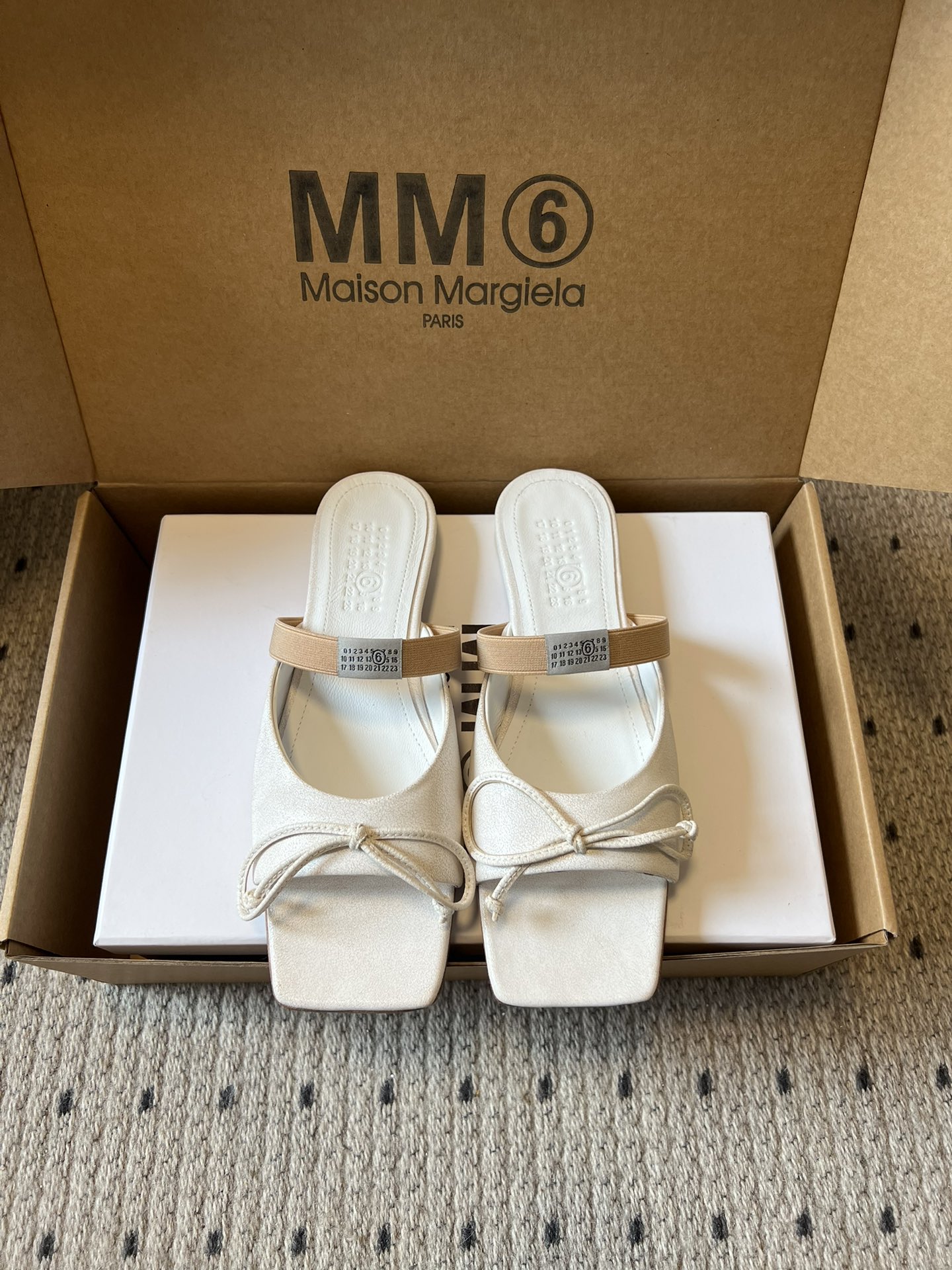 NO:653395,Maison Margiel* square toe elastic band ballet flat sandals adopt the brand's iconic sculptural silhouette that fits the shape of the foot. The upper is soft and smooth, taking into account both fit and design. The square toe + ballet elements are combined with the classic square toe design to create a modern feel. It is paired with the bow decoration on the upper to reconstruct the elegant outline of the ballet shoes. At the same time, it is made into a mules back style, which is both casual and refined.  There is the iconic white single-thread stitching on the heel, and the elastic band of the shoe body has the MM6 digital logo, which is the key to brand recognition. The empty mule slip structure simplifies the way of putting on and taking off, combining the softness of ballet shoes with the casualness of mule shoes. The upper is retro burst cowhide, the lining is silk sheepskin, the outsole is genuine leather, and the height is increased by 2.5cm.  margiela,sandals,flats,slippers,cowhide,sheepskin,leather soles19860909Maison Margiel*方头弹力带芭蕾鞋平底鞋凉鞋 采用品牌标志性的贴合脚型的雕塑感轮廓,鞋面柔软且线条流畅,兼顾贴合度与设计感.方头+芭蕾元素融合经典方头设计打造现代感,搭配鞋面蝴蝶结装饰,重构芭蕾鞋的优雅轮廓,同时做穆勒拖的后空款式,兼具休闲与精致. 鞋后跟处有标志性的白色单线缝线,鞋身弹性带带有MM6数字标识,是品牌辨识度的关键.后空的穆勒拖结构,简化穿脱方式,将芭蕾鞋的柔美与穆勒鞋的随性结合. 鞋面复古爆裂牛皮 内里丝绸羊皮里 大底真皮大底 增高2.5cm size :35-41码（40、41码定制不退换）,拖鞋芭蕾舞鞋,masion margiela,sandals,flats,slippers,cowhide,sheepskin,Leather soles,Women's Shoes