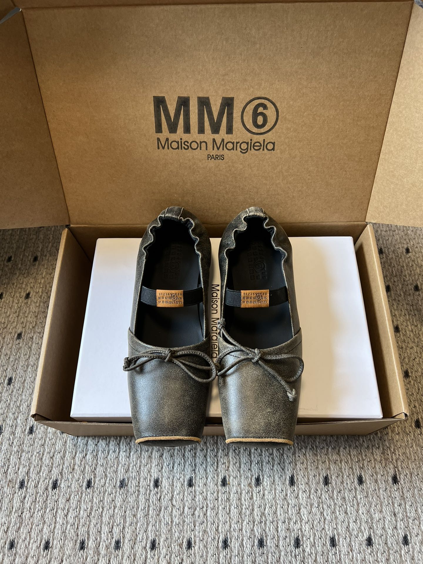 NO:653402,Maison Margiel* square toe elastic band ballet flat Mary Jane shoes adopt the brand's iconic sculptural silhouette that fits the shape of the foot. The upper is soft and smooth, taking into account both fit and design. The square toe + ballet elements are combined with the classic square toe design to create a modern feel. It is paired with the bow decoration on the upper to reconstruct the elegant outline of the ballet shoes. At the same time, it is made into a mules back style, which is both casual and refined.  There is the iconic white single-thread stitching on the heel, and the elastic strap of the shoe body has the MM6 number logo, which is the key to brand recognition. The flat Mary Jane style simplifies the way of putting on and taking off, combining the softness of ballet shoes with the casualness of mules. The upper is retro burst cowhide, the lining is silk sheepskin, the outsole is genuine leather, and the height is increased by 2.5cm. Size: 35-41 (customized sizes 40 and 41 are not returnable), slippers ballet shoes, masion  margiela,mary jane,slippers,cowhide,sheepskin,Leather soles19860909Maison Margiel*方头弹力带芭蕾鞋平底玛丽珍鞋单鞋 采用品牌标志性的贴合脚型的雕塑感轮廓,鞋面柔软且线条流畅,兼顾贴合度与设计感.方头+芭蕾元素融合经典方头设计打造现代感,搭配鞋面蝴蝶结装饰,重构芭蕾鞋的优雅轮廓,同时做穆勒拖的后空款式,兼具休闲与精致. 鞋后跟处有标志性的白色单线缝线,鞋身弹性带带有MM6数字标识,是品牌辨识度的关键.平底玛丽珍款式,简化穿脱方式,将芭蕾鞋的柔美与穆勒鞋的随性结合. 鞋面复古爆裂牛皮 内里丝绸羊皮里 大底真皮大底 增高2.5cm size :35-41码（40、41码定制不退换）,拖鞋芭蕾舞鞋,masion margiela,mary jane,slippers,cowhide,sheepskin,Leather soles,Women's Shoes