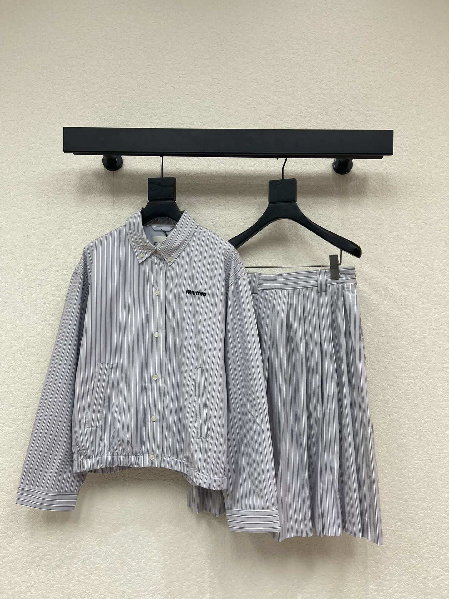 NO:663341,coat  Skirt Miumi*26 early spring new striped lapel jacket, drawstring skirt suit. Customized YB twill cotton material, comfortable texture, stylish to wear, lapel shirt-style contour jacket, full of fashionable style, all-over blue stripes are arranged vertically, the back button can be detached, the hem is elastic threaded, and the fit is more obvious  The figure is decorated with an embroidered logo on the chest, and the outfit shows your individual style. Pair it with the skirt of the same series. The mid-length A-line style with perforated belt and neat pleats. The umbrella-shaped flared skirt shape modifies the leg shape and makes the legs slimmer and looser. The complete set is more brand attractive and fashionable. SML,,miumiu,skirts,jackets  & coats,jackets & coats,shirts, 19860909外套 半裙Miumi*26早春新款条纹翻领夹克外套抽绳半裙套装.定制YB斜纹全棉材质,质感舒适,穿搭有型,翻领衬衫式轮廓夹克外套,尽显时髦格调穿搭,通体蓝色对条条纹竖状排列,后背纽扣可拆分,下摆弹力螺纹包边,贴合更显身材,胸前刺绣徽标装饰,穿搭尽显个性风采,搭配同系列半身裙,腰带穿孔A字中长款配利落压褶,伞状外扩裙边造型,修饰腿形显瘦松弛,成套搭配更具品牌魅力,时髦潮流.SML,,miumiu,skirts,jackets & coats,jackets & coats,shirts, ,Women's clothing