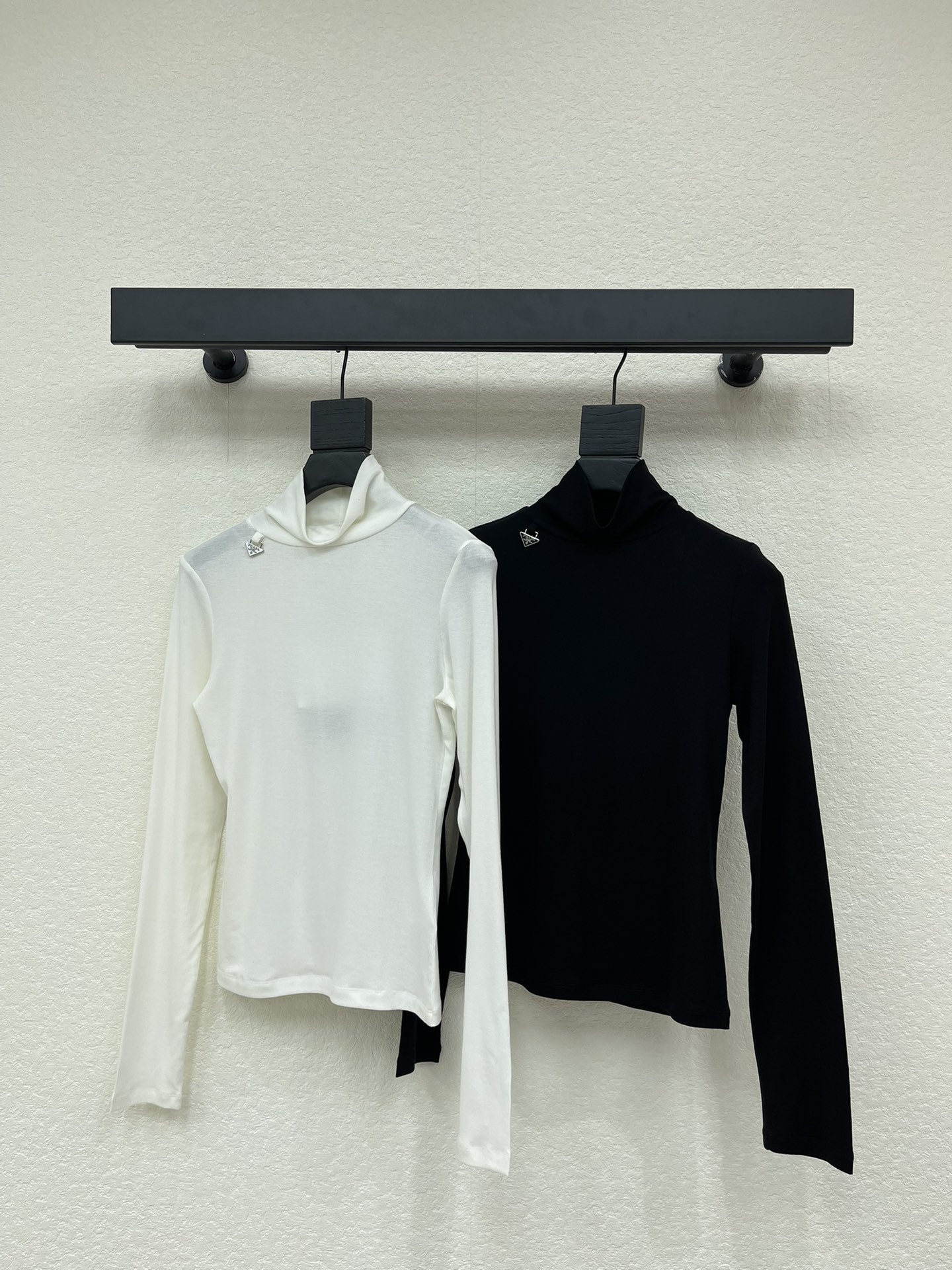 NO:663346,Prad*26 early spring new high-neck metal logo bottoming shirt. Customized YB Tencel wool material, soft and delicate, comfortable texture, high-neck bottoming shirt cut, the whole body is plain and versatile, the yarn fabric is elastic, fits the body curve, visually slimming, the triangle metal letter logo hangs on the side of the collar, showing the brand tonality, low-key and texture. Versatile and simple style, worn alone and layered to show your temperament, suitable for daily commuting. SML A,, prada,  19860909Prad*26早春新款高领金属徽标打底衫.定制YB天丝羊毛材质,柔软细腻,质感舒适,高领打底衫剪裁,通体素色百搭耐看,纱线面料弹性十足,贴合身体曲线,视觉显瘦,领口侧面吊挂三角金属字母徽标,展现品牌调性,低调有质感.百搭简约款式,单穿叠穿上身尽显气质,日常通勤都.SML A,,prada, ,Women's clothing