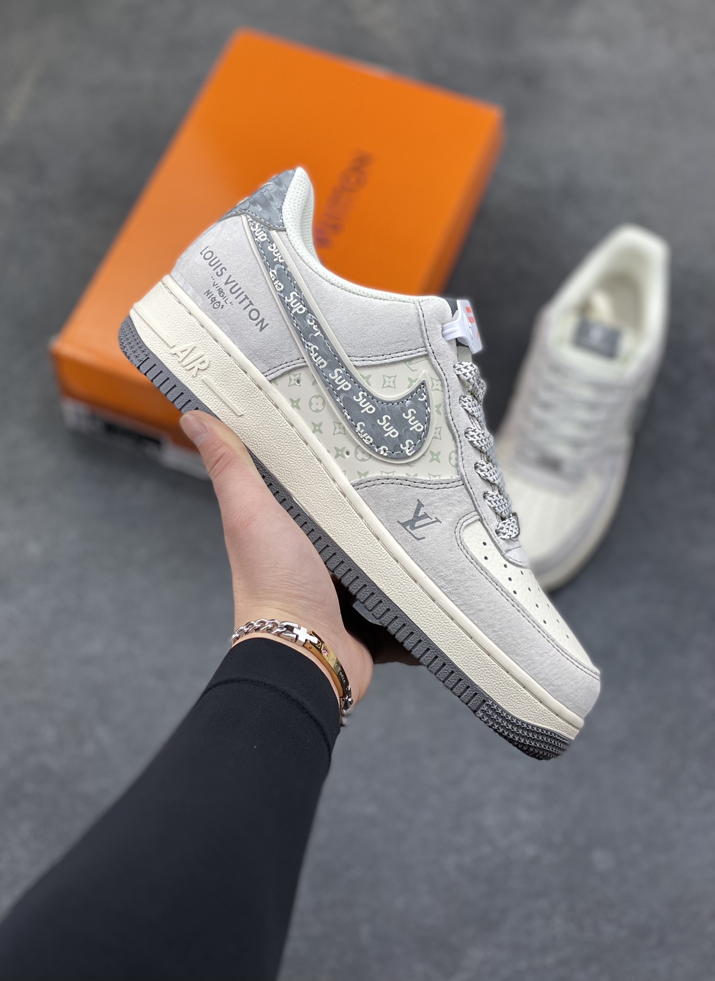 Air Force 1 Low x LV x Supreme 联名款｜顶奢与街头的终极融合！当Nike Air Force 1的经典轮廓，遇上Louis Vuitton的高奢基因，再叠加Supreme的街头潮范，这双Air Force 1 Low CX5050-Y48直接成为潮流圈的“王炸单品”！ 浅灰色磨砂皮革鞋身质感拉满，鞋侧Swoosh满印Supreme标志性字母，LV经典老花图案以浅绿调低调点缀，鞋身“LOUIS VUITTON”标识醒目又不张扬，三大顶流品牌的元素碰撞出极致的视觉张力。粗织鞋带搭配做旧感米白中底，再以深灰外底收尾，复古与奢华的平衡感被拿捏得恰到好处。作为经典的空军一号低帮版型，它保留了AF1标志性的气垫缓震与百搭属性，同时通过奢牌联名的细节重塑，让这双鞋既拥有日常上脚的舒适，又具备收藏级的稀缺价值。不管是搭配高街风穿搭凸显个性，还是作为潮流收藏彰显品味，这双跨界联名款都能成为造型中的绝对焦点。这双集Nike的运动底蕴、LV的奢华格调、Supreme的街头态度于一体的Air Force 1，是真正意义上跨越圈层的潮流杰作，也是硬核玩家的必入典藏！-选品中心
