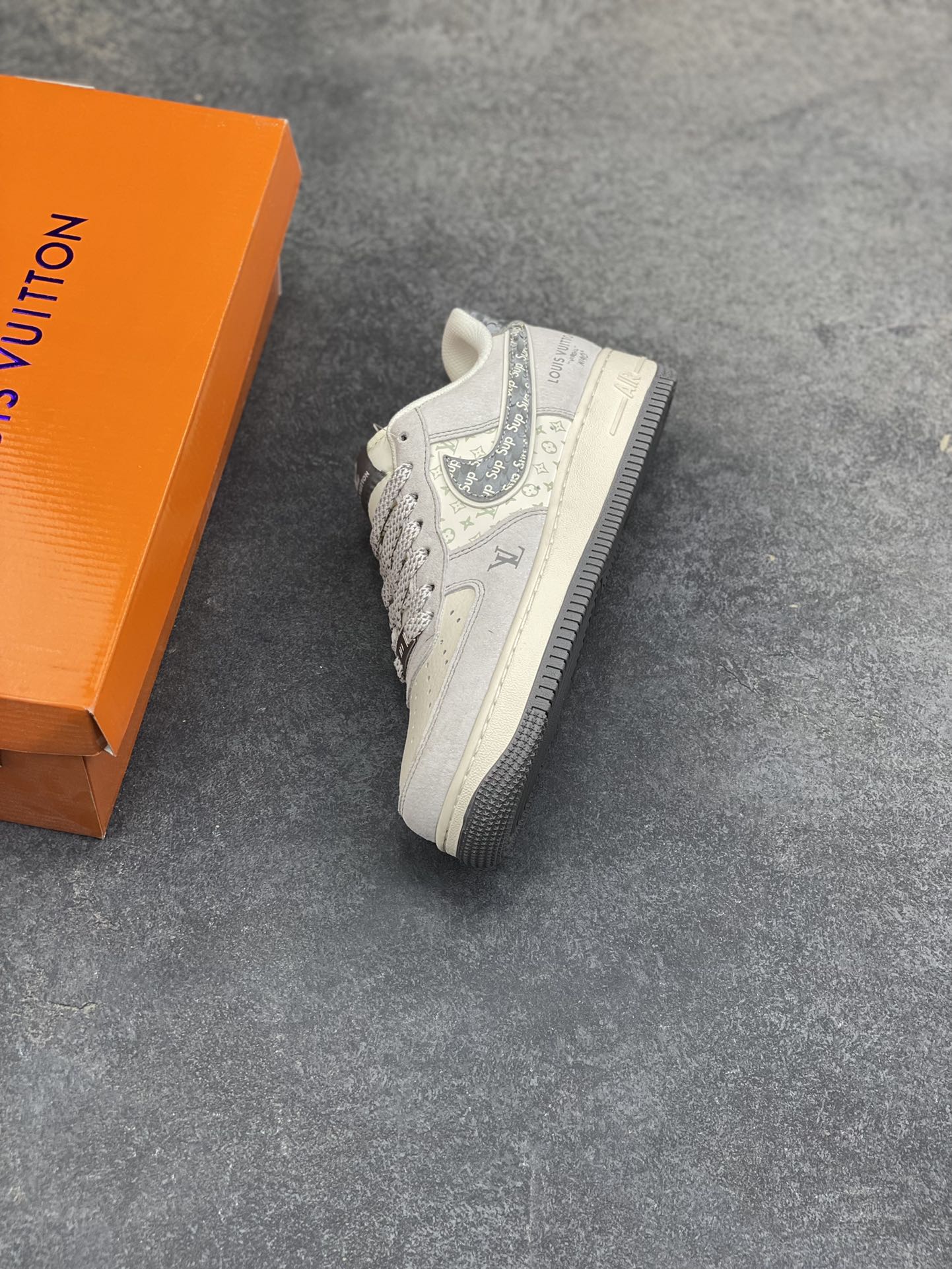 图片[7]-Air Force 1 Low x LV x Supreme 联名款｜顶奢与街头的终极融合！当Nike Air Force 1的经典轮廓，遇上Louis Vuitton的高奢基因，再叠加Supreme的街头潮范，这双Air Force 1 Low CX5050-Y48直接成为潮流圈的“王炸单品”！ 浅灰色磨砂皮革鞋身质感拉满，鞋侧Swoosh满印Supreme标志性字母，LV经典老花图案以浅绿调低调点缀，鞋身“LOUIS VUITTON”标识醒目又不张扬，三大顶流品牌的元素碰撞出极致的视觉张力。粗织鞋带搭配做旧感米白中底，再以深灰外底收尾，复古与奢华的平衡感被拿捏得恰到好处。作为经典的空军一号低帮版型，它保留了AF1标志性的气垫缓震与百搭属性，同时通过奢牌联名的细节重塑，让这双鞋既拥有日常上脚的舒适，又具备收藏级的稀缺价值。不管是搭配高街风穿搭凸显个性，还是作为潮流收藏彰显品味，这双跨界联名款都能成为造型中的绝对焦点。这双集Nike的运动底蕴、LV的奢华格调、Supreme的街头态度于一体的Air Force 1，是真正意义上跨越圈层的潮流杰作，也是硬核玩家的必入典藏！-选品中心