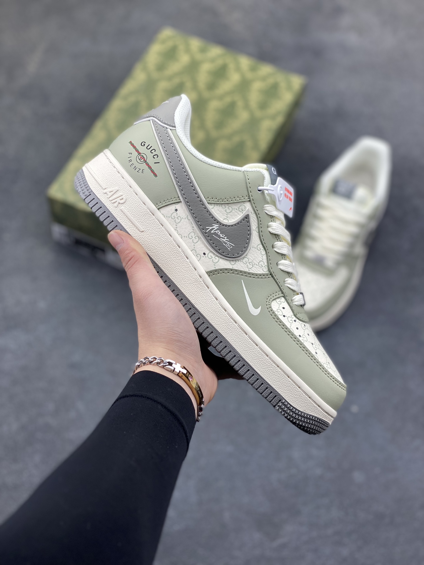 Nike Air Force 1 Low 邂逅奢牌老花基因，直接把高奢与街头的碰撞玩到极致。浅灰调的皮质鞋身搭配米白色老花暗纹，鞋侧的深灰 Swoosh 上还点缀着手写签名式纹路，后跟的 GUCCI FIRENZE 标识更是将奢潮融合的氛围感拉满。经典的 AF1 低帮鞋型搭配米白做旧中底，浅灰橡胶外底收尾，既保留了空军一号的街头灵魂，又凭借老花元素和奢牌细节，打造出独一无二的高端质感。不管是日常出街还是搭配轻奢风造型，这双鞋都能成为造型里的吸睛利器，让复古奢潮与街头经典完美共生。 货号：XS1958-621-选品中心