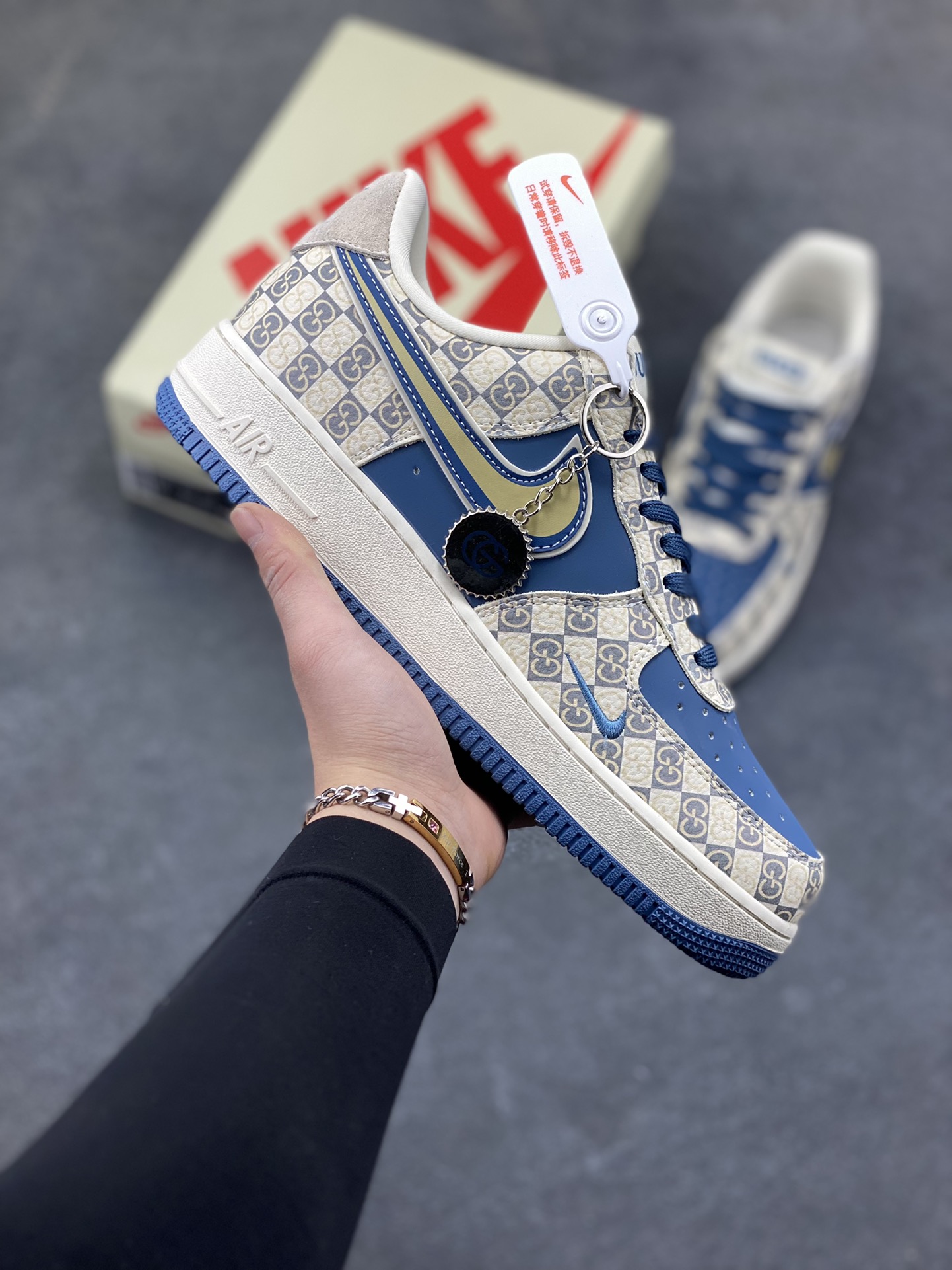 当经典的 Air Force 1 Low 遇上复古老花棋盘格，深海蓝的皮质拼接搭配米金色 Swoosh 勾边，瞬间拉满复古格调。从鞋头到鞋跟的细节雕琢，将老花元素与街头潮流完美融合，米白中底搭配藏蓝外底的撞色设计，不仅踩出舒适脚感，更让每一步都自带复古美学滤镜。无论是日常穿搭还是街头出片，这双 AF1 都能成为造型里的点睛之笔，把小众质感与经典款的魅力狠狠拿捏。货号：XL1979-127-选品中心