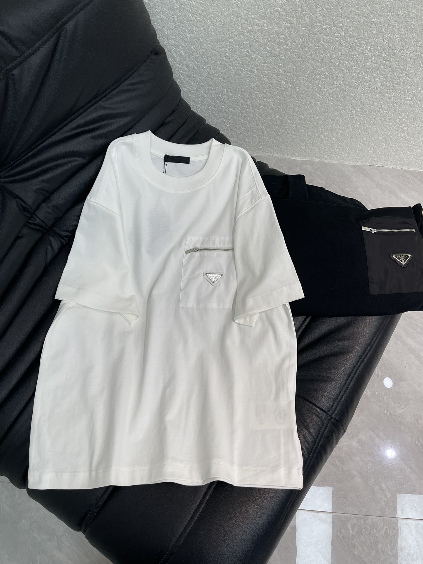 NO:664096,PRAD*26 new spring and summer short-sleeved T-shirt with triangle logo nylon zipper pocket. High-weight pure cotton fabric is comfortable and breathable. Re-Nylon regenerated nylon zipper pocket metal triangle logo on the front shows iconic elements. Full of details, creating a casual effect, fashionable and versatile, the same style for men and women!  S-XL,,prada,T-shirt,tees,t-shirt, 19860909PRAD*26春夏新款三角标尼龙拉链口袋短袖T恤.高克重纯棉面料舒适透气.正面Re-Nylon再生尼龙拉链口袋金属三角形徽标展现标志性元素.细节满满 打造休闲效果 时尚百搭款 男女同款！S-XL,,prada,T-shirt,tees，t-shirt, ,Women's clothing