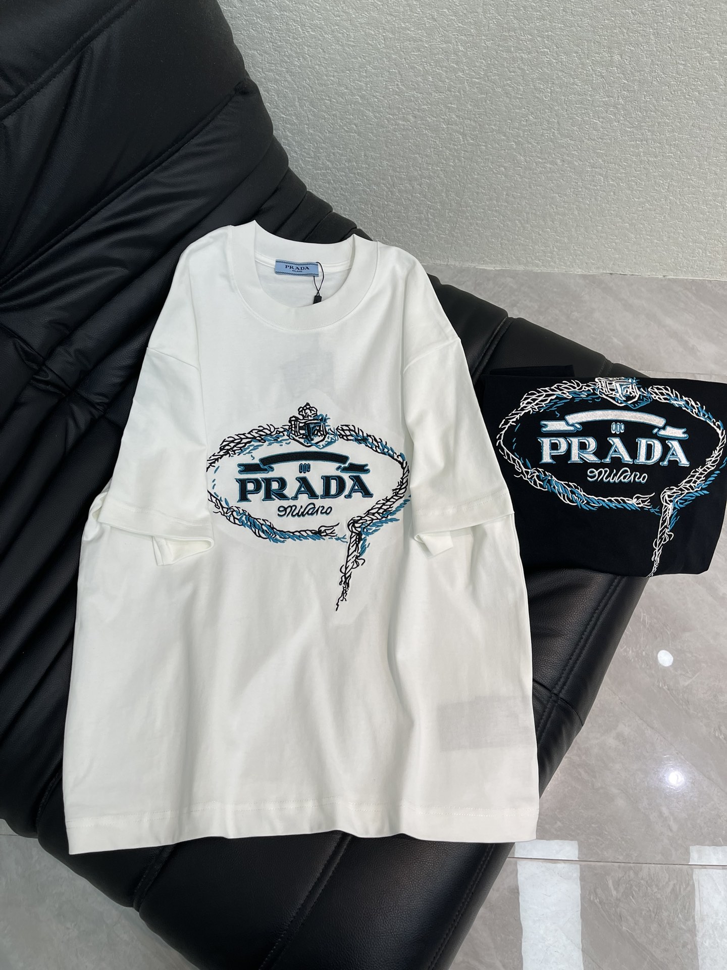 NO:665167,PRAD*26 new spring and summer contrasting color embroidered logo short-sleeved T-shirt. High-weight pure cotton fabric, soft and breathable, super comfortable for daily wear! The oval border on the chest is integrated with the brand logo embroidery to present a full artistic sense. A very fashionable style, the overall design is simple yet individual, suitable for urban men and women who pursue fashion trends and pay attention to brand culture, and can easily handle various occasions. The same style for men and women!  S-XL,,prada,T-shirt,tees,t-shirt, 19860909PRAD*26春夏新款撞色刺绣标识短袖T恤.高克重纯棉面料,柔软透气,日常穿着超舒适!胸前椭圆形边框融合品牌标志刺绣呈现满满艺术感.非常时尚的一个款,整体设计简约而不失个性,适合追求时尚潮流、注重品牌文化的都市男女,轻松驾驭多种场合.男女同款！S-XL,,prada,T-shirt,tees，t-shirt, ,Women's clothing