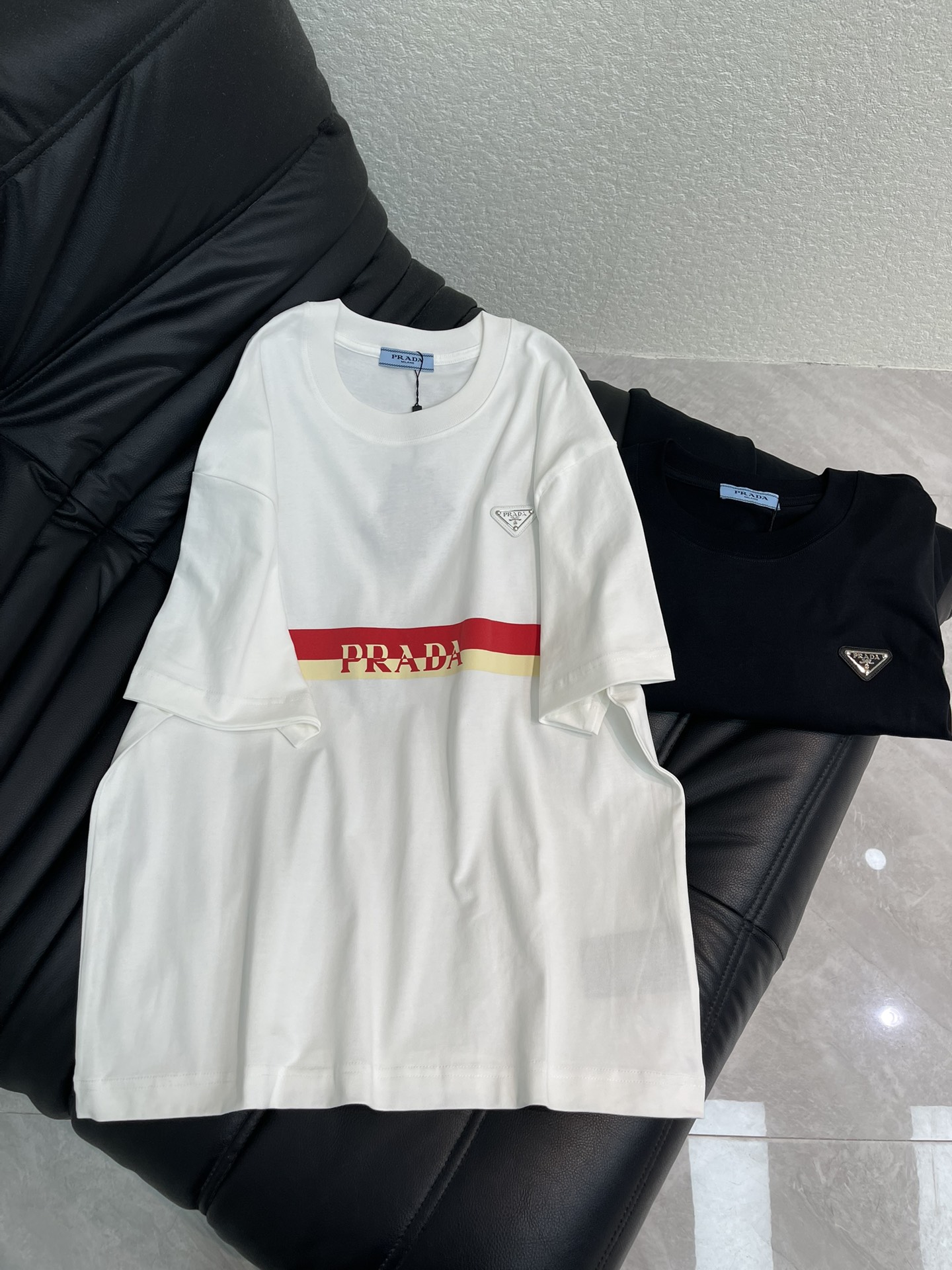 NO:665153,Prad*26 new spring and summer new metal triangle logo short-sleeved T-shirt. Customized high-weight cotton fabric, soft, skin-friendly and comfortable. Contrast color strip letter printing technology in the middle, three-dimensional texture, highly recognizable! A very fashionable style, the overall design is simple yet individual, suitable for urban men and women who pursue fashion trends and pay attention to brand culture, and can easily handle various occasions. The same style for men and women!  S-XL,,prada,T-shirt,tees,t-shirt, 19860909Prad*26春夏新款金属三角标短袖T恤.定制高克重全棉面料,面料柔软,亲肤舒适.中间撞色条字母印花工艺,质感立体,辨识度超高!非常时尚的一个款,整体设计简约而不失个性,适合追求时尚潮流、注重品牌文化的都市男女,轻松驾驭多种场合.男女同款！S-XL,,prada,T-shirt,tees，t-shirt, ,Women's clothing