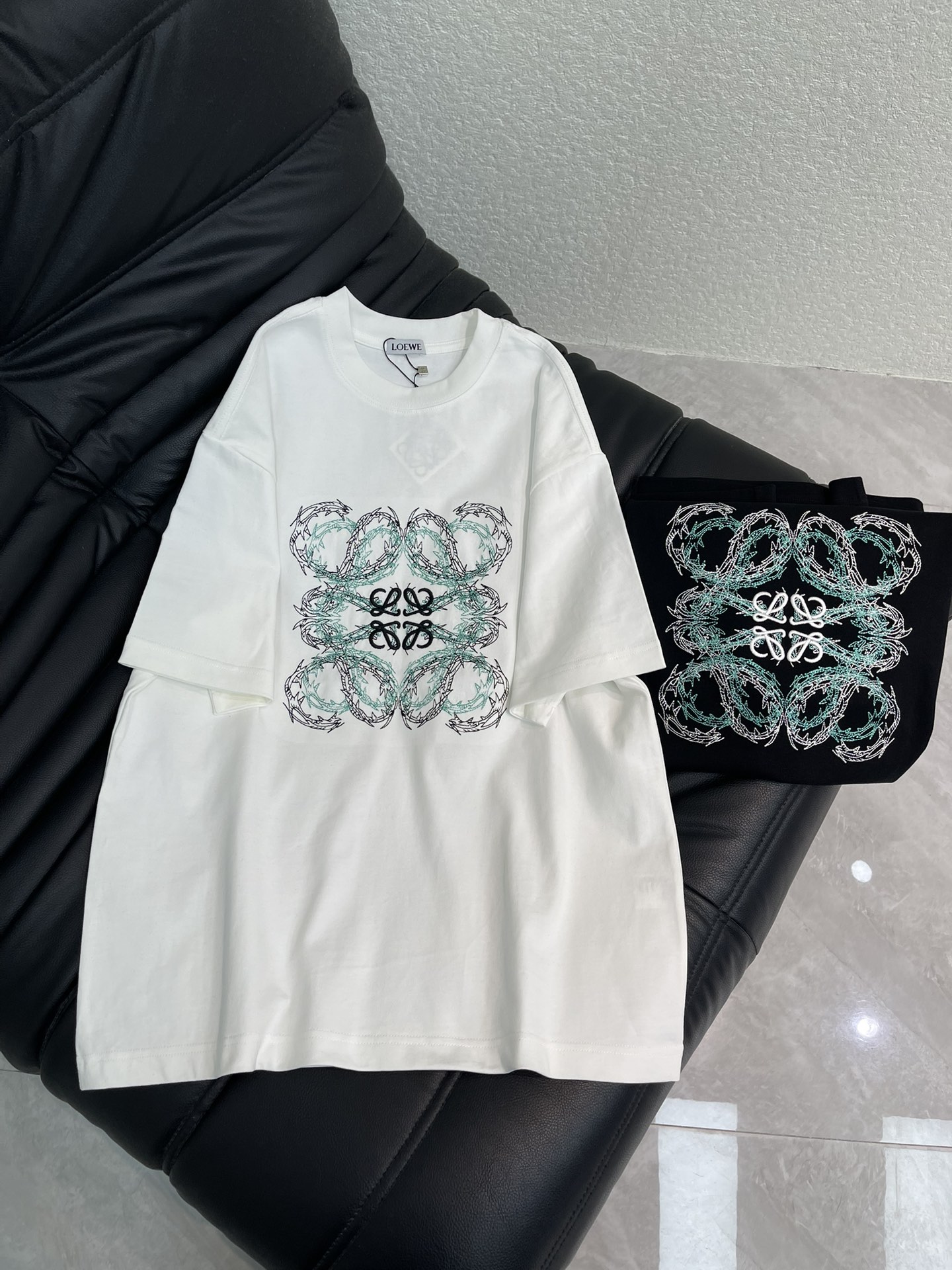 NO:664187,Loew*26 new spring and summer embroidered short-sleeved T-shirt. High-weight pure cotton fabric, breathable and comfortable. The embroidery process uses thousands of floral embroidery stitches to design a square pattern composed of four intertwined floral 'L's, and uses black and green silk threads to depict exquisite artistic fonts. It declares the brand's design concept that has been inherited for many years!  Its eye-catching appeal is no less than any classic style, perfectly presenting a sense of fashion, high-end and luxury!  Versatile style for men and women!  S-XL A,,loewe,T-shirt,tees,t-shirt, 19860909Loew*26春夏新款刺绣短袖T恤.高克重纯棉面料 透气舒适.刺绣工艺以万针花饰刺绣针法设计了由四个缠绕的花体“L”组成的方形图案,以黑色和绿色丝线来描绘精致的艺术字体.宣示品牌传承多年的设计理念！其吸睛度完全不亚于任何经典款式,将时髦高级感与奢华感完美呈现眼前！百搭款 男女同款！S-XL A,,loewe,T-shirt,tees，t-shirt, ,Women's clothing