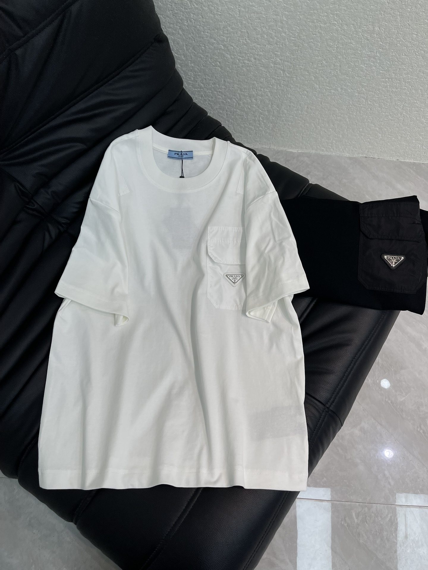 NO:664118,PRAD*26 new spring and summer short-sleeved T-shirt with triangle logo nylon pocket. High-weight pure cotton fabric is comfortable and breathable. Re-Nylon regenerated nylon open pocket metal triangle logo on the front shows iconic elements. Full of details to create a casual effect, fashionable and versatile, same style for men and women!  S-XL A,,prada,T-shirt,tees,t-shirt, 19860909PRAD*26春夏新款三角标尼龙口袋短袖T恤.高克重纯棉面料舒适透气.正面Re-Nylon再生尼龙开口口袋金属三角形徽标展现标志性元素.细节满满 打造休闲效果 时尚百搭款 男女同款！S-XL A,,prada,T-shirt,tees，t-shirt, ,Women's clothing