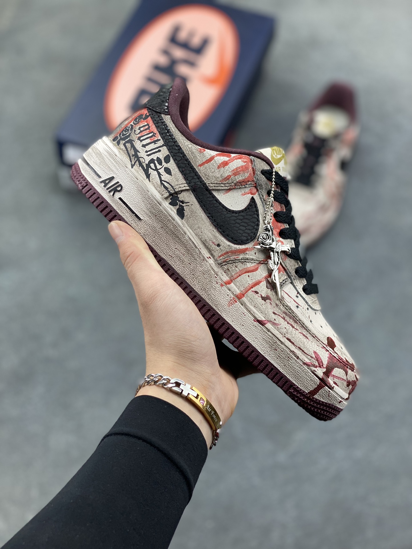 手绘涂鸦“哥特血痕”Nike Air Force 1 “Gothic Bloodstains”空军一号定制板鞋 以 “哥特暗黑美学” 为核心，将做旧米白基底化作画布：猩红血痕如泼墨般蜿蜒，与黑调涂鸦、“GOTH” 字样碰撞出颓废张力；鞋侧挂坠以十字架缠玫瑰的造型，锚定暗黑浪漫的灵魂。做旧质感与先锋细节交织，让日常鞋履成为游走于叛逆与艺术间的风格符号，每一处磨损与色彩晕染，都是独属于亚文化美学的野生表达 货号：XL2132-888 尺码： 36 36.5 37.5 38 38.5 39 40 40.5 41 42 42.5 43 44 44.5 45-选品中心