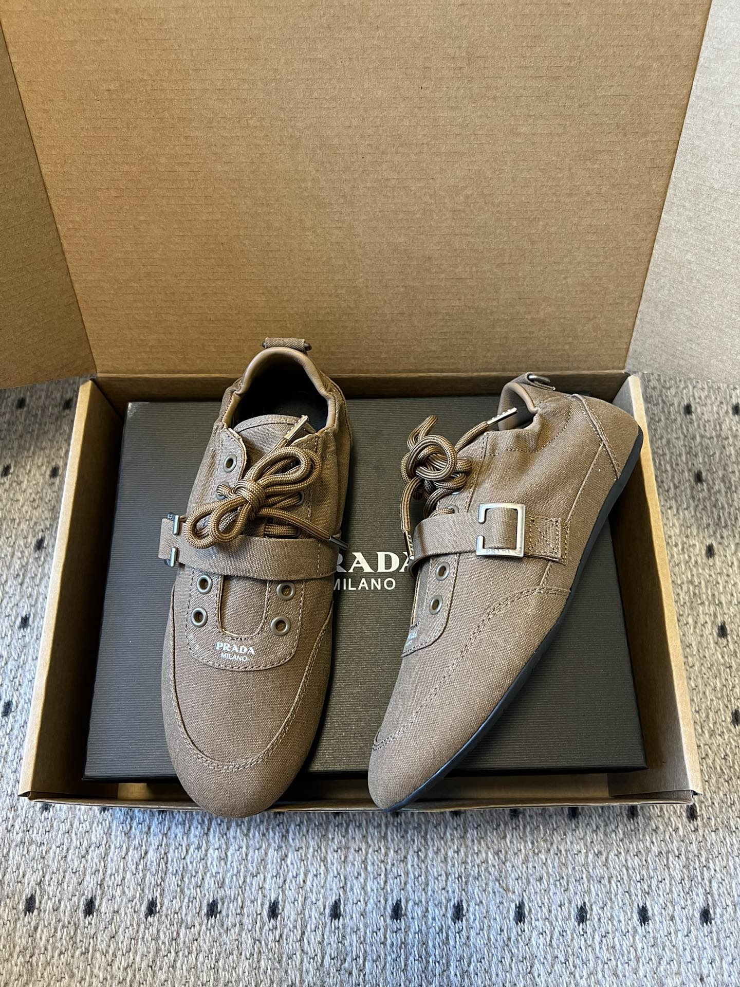 Prad*复古绑带平底休闲鞋阿甘鞋鞋面采用帆布质感的面料，质感细腻，结合系带与魔术贴搭扣双重固定设计，兼