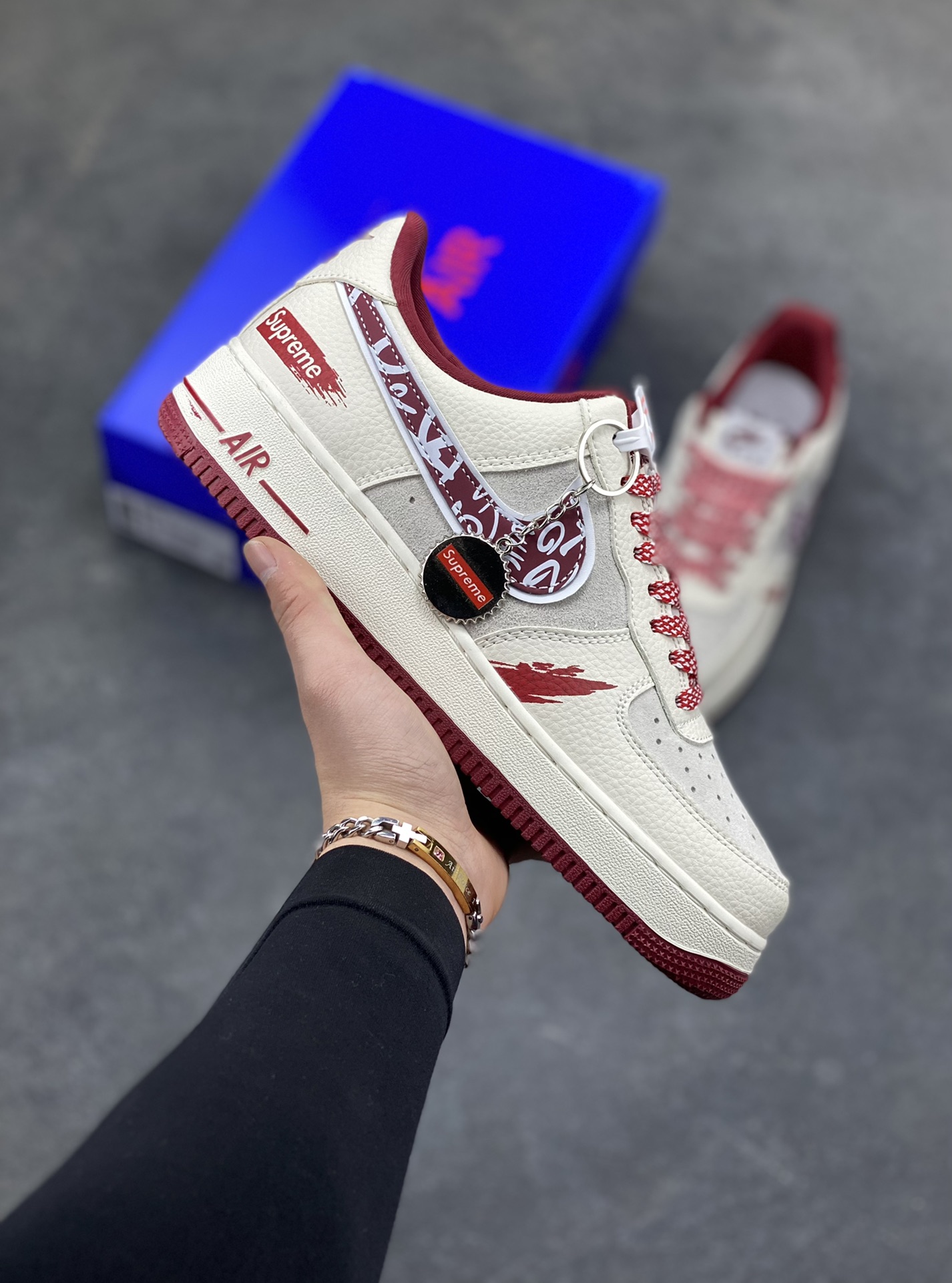 𝐍𝐢𝐤𝐞 𝐀𝐢𝐫 𝐅𝐨𝐫𝐜𝐞 1 𝐋𝐨𝐰 × Supreme 联名款｜街头顶流的碰撞！当空军一号的经典轮廓遇上Supreme的街头狂想，这双SY1388-019直接把潮流辨识度拉满！鞋身以米白荔枝纹皮革为主调，拼接浅灰翻毛皮打造层次质感，酒红色调从鞋舌、鞋领延伸至中底包边，成为视觉焦点。标志性Swoosh覆盖满印涂鸦花纹，鞋侧的Supreme红标醒目又张扬，鞋头的泼墨红纹更是细节感拉满，将街头艺术与经典鞋型的融合玩到极致。经典低帮AF1鞋型兼顾百搭与脚感，软弹Air气垫加持日常行走毫无压力，不管是搭配工装裤还是运动束脚裤，都能轻松穿出街头潮酷范，堪称潮人鞋柜里的“硬通货”！-选品中心
