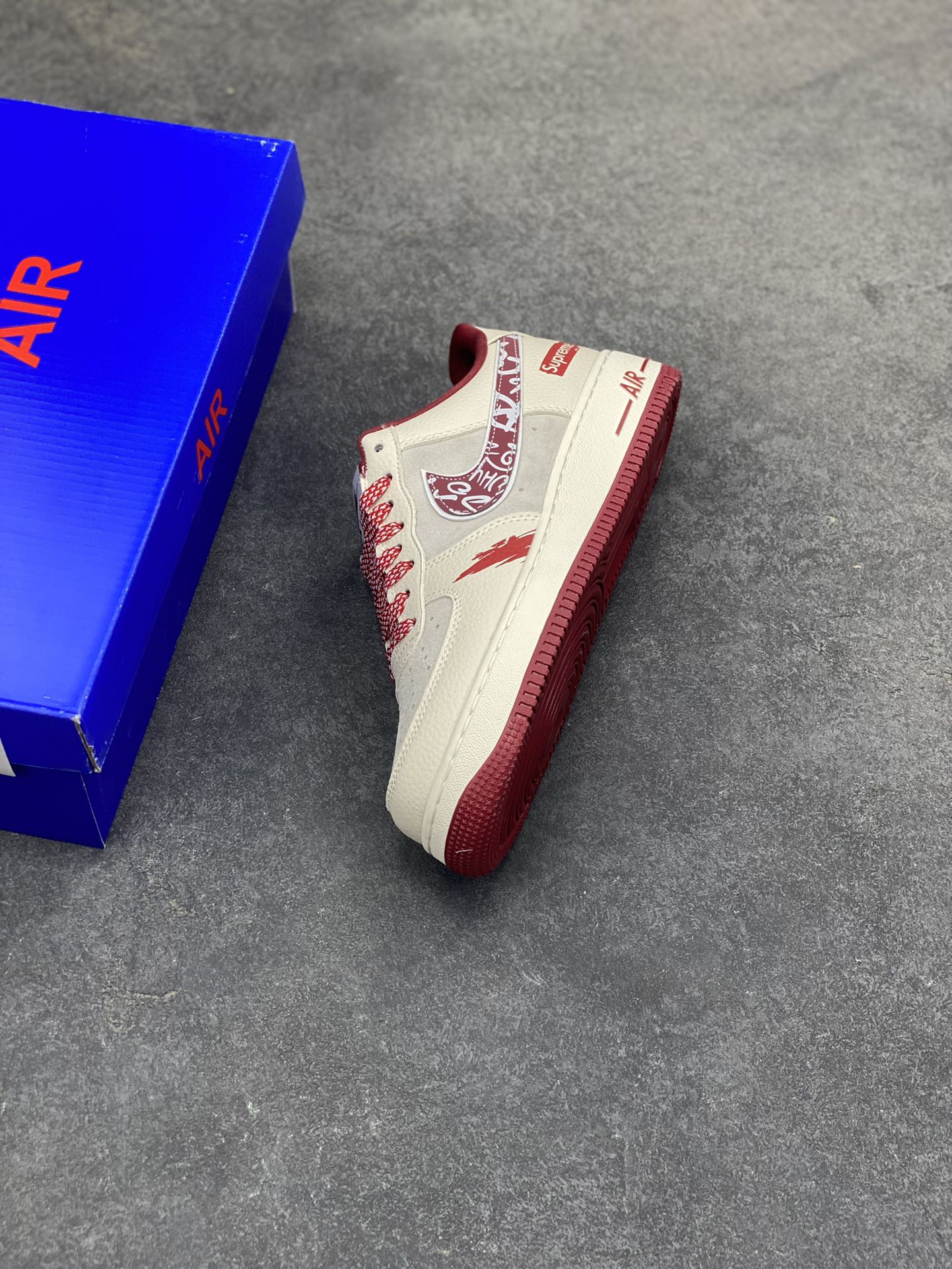 图片[7]-𝐍𝐢𝐤𝐞 𝐀𝐢𝐫 𝐅𝐨𝐫𝐜𝐞 1 𝐋𝐨𝐰 × Supreme 联名款｜街头顶流的碰撞！当空军一号的经典轮廓遇上Supreme的街头狂想，这双SY1388-019直接把潮流辨识度拉满！鞋身以米白荔枝纹皮革为主调，拼接浅灰翻毛皮打造层次质感，酒红色调从鞋舌、鞋领延伸至中底包边，成为视觉焦点。标志性Swoosh覆盖满印涂鸦花纹，鞋侧的Supreme红标醒目又张扬，鞋头的泼墨红纹更是细节感拉满，将街头艺术与经典鞋型的融合玩到极致。经典低帮AF1鞋型兼顾百搭与脚感，软弹Air气垫加持日常行走毫无压力，不管是搭配工装裤还是运动束脚裤，都能轻松穿出街头潮酷范，堪称潮人鞋柜里的“硬通货”！-选品中心