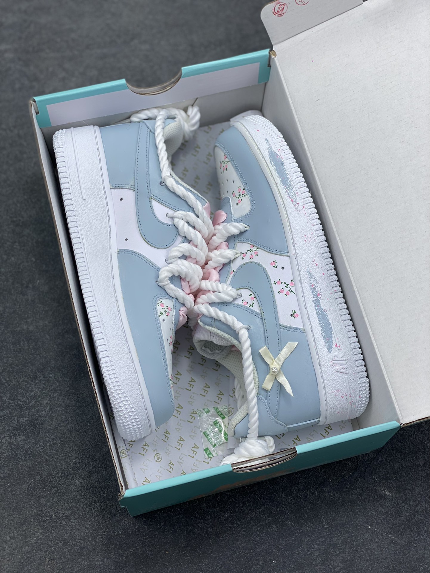 图片[9]-手绘涂鸦“浅樱雾语”Nike Air Force 1 “Pale Cherry Mist Whisper”空军一号定制板鞋 这双客制 AF1 以 “春日柔雾” 为基调，浅薄荷蓝与奶白交织出清透质感：鞋身散落的粉樱碎花像揉碎的春日光影，绳结鞋带与缎面蝴蝶结叠搭出甜而不腻的软萌氛围，鞋边的淡粉泼墨更添几分随性松弛。把春日的柔雾与花意穿在脚上，是少女感与轻甜美学的具象化表达 货号：DH2920-121 尺码： 36 36.5 37.5 38 38.5 39 40 40.5 41 42 42.5 43 44 44.5 45-选品中心