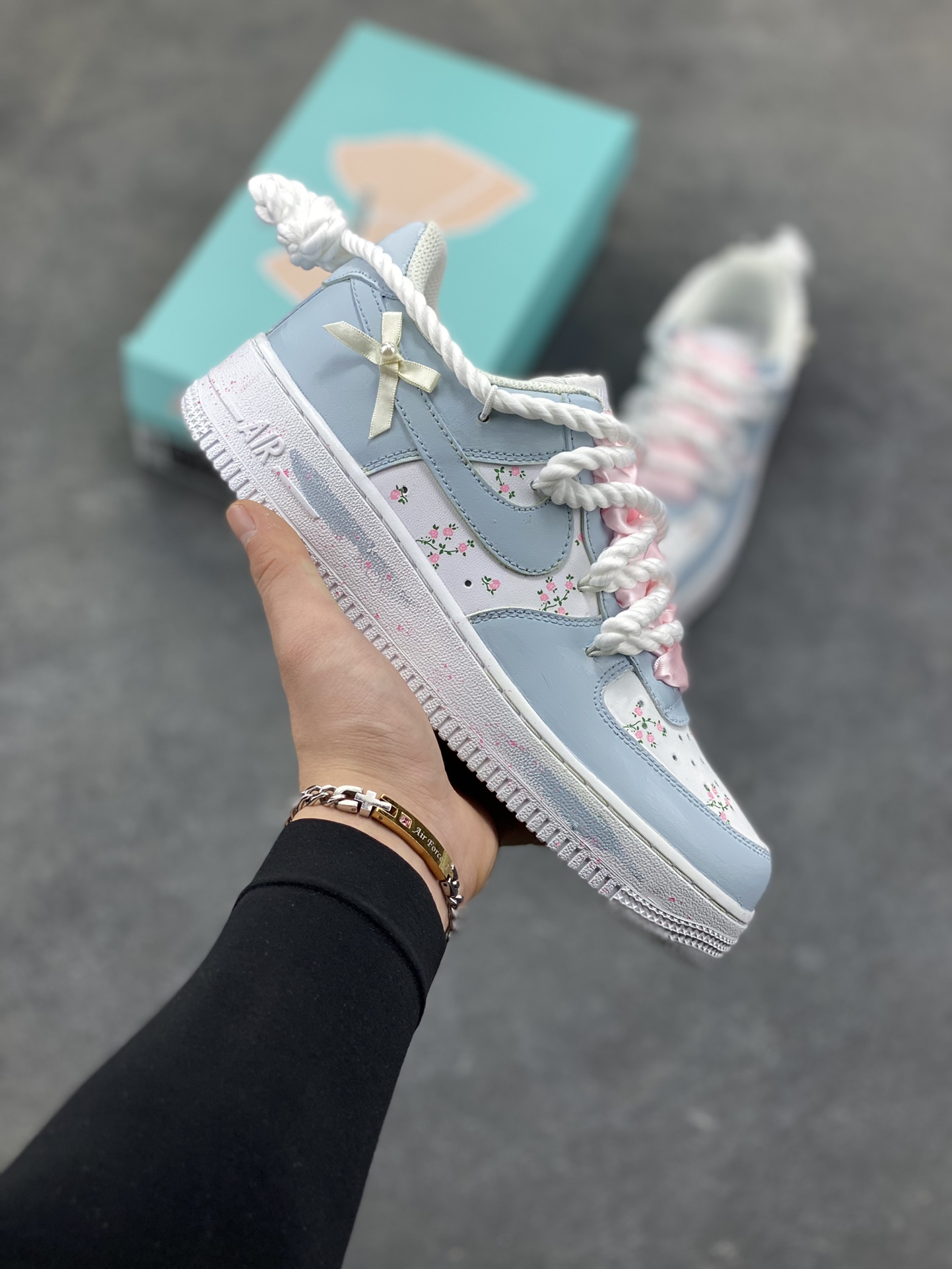 手绘涂鸦“浅樱雾语”Nike Air Force 1 “Pale Cherry Mist Whisper”空军一号定制板鞋 这双客制 AF1 以 “春日柔雾” 为基调，浅薄荷蓝与奶白交织出清透质感：鞋身散落的粉樱碎花像揉碎的春日光影，绳结鞋带与缎面蝴蝶结叠搭出甜而不腻的软萌氛围，鞋边的淡粉泼墨更添几分随性松弛。把春日的柔雾与花意穿在脚上，是少女感与轻甜美学的具象化表达 货号：DH2920-121 尺码： 36 36.5 37.5 38 38.5 39 40 40.5 41 42 42.5 43 44 44.5 45-选品中心
