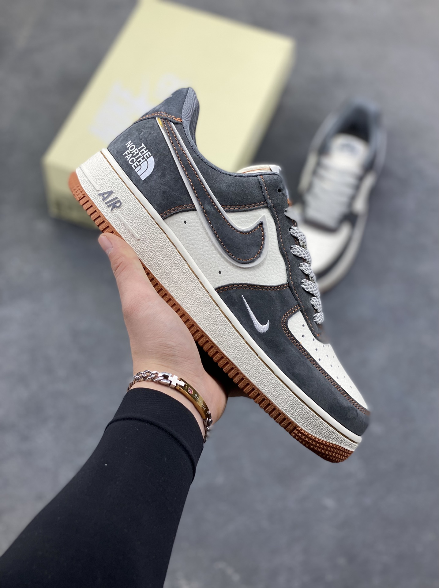 Nike Air Force 1 Low x The North Face 联名款｜硬核潮搭新标杆！当经典空军一号遇上户外王者北面，这双SS1979-005配色的Air Force 1 Low直接把街头潮流与户外机能风焊死在鞋面上！深灰磨砂麂皮碰撞米白皮革，橙棕车线勾勒出硬朗的户外质感，鞋侧双品牌标识强强联手，既有AF1的复古板鞋基因，又融入The North Face的户外硬核气场。生胶外底搭配Air气垫，踩屎感拉满的同时，复古氛围直接拉到顶点。不管是搭配工装裤走街头户外风，还是配牛仔裤搭休闲造型，这双鞋都能成为造型的点睛之笔，潮人鞋柜里的“王炸款”非它莫属！-选品中心