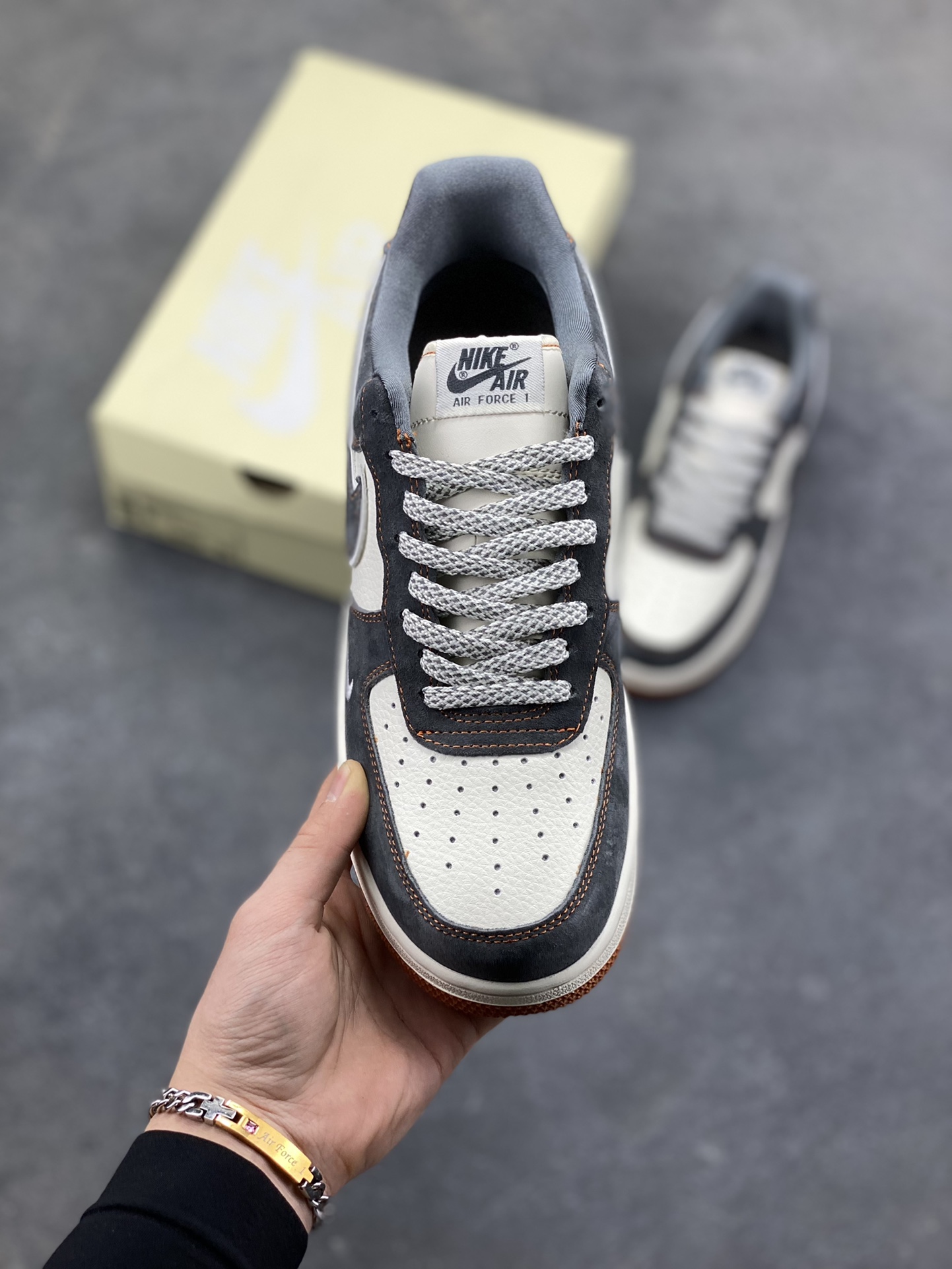 图片[2]-Nike Air Force 1 Low x The North Face 联名款｜硬核潮搭新标杆！当经典空军一号遇上户外王者北面，这双SS1979-005配色的Air Force 1 Low直接把街头潮流与户外机能风焊死在鞋面上！深灰磨砂麂皮碰撞米白皮革，橙棕车线勾勒出硬朗的户外质感，鞋侧双品牌标识强强联手，既有AF1的复古板鞋基因，又融入The North Face的户外硬核气场。生胶外底搭配Air气垫，踩屎感拉满的同时，复古氛围直接拉到顶点。不管是搭配工装裤走街头户外风，还是配牛仔裤搭休闲造型，这双鞋都能成为造型的点睛之笔，潮人鞋柜里的“王炸款”非它莫属！-选品中心