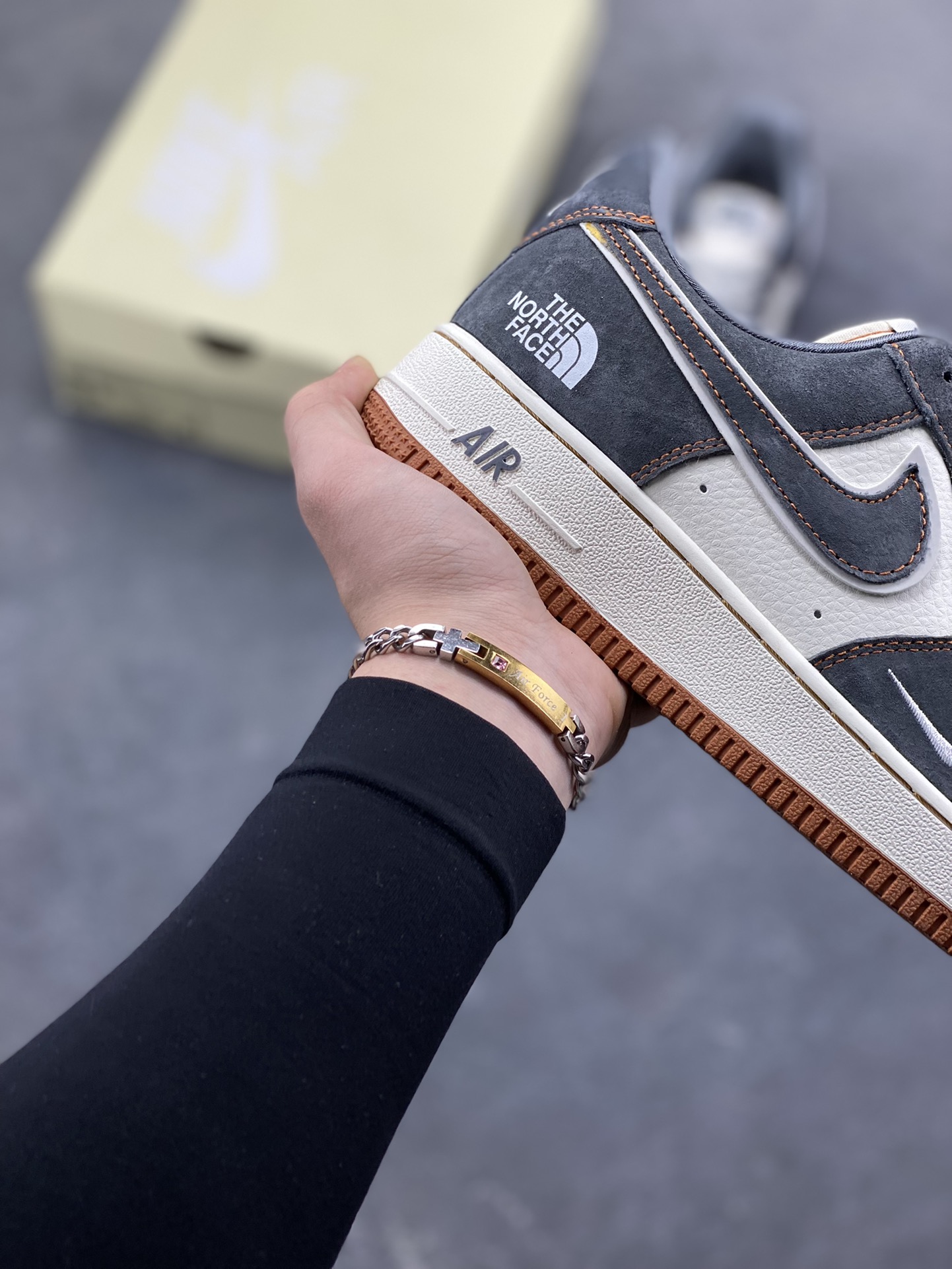 图片[6]-Nike Air Force 1 Low x The North Face 联名款｜硬核潮搭新标杆！当经典空军一号遇上户外王者北面，这双SS1979-005配色的Air Force 1 Low直接把街头潮流与户外机能风焊死在鞋面上！深灰磨砂麂皮碰撞米白皮革，橙棕车线勾勒出硬朗的户外质感，鞋侧双品牌标识强强联手，既有AF1的复古板鞋基因，又融入The North Face的户外硬核气场。生胶外底搭配Air气垫，踩屎感拉满的同时，复古氛围直接拉到顶点。不管是搭配工装裤走街头户外风，还是配牛仔裤搭休闲造型，这双鞋都能成为造型的点睛之笔，潮人鞋柜里的“王炸款”非它莫属！-选品中心