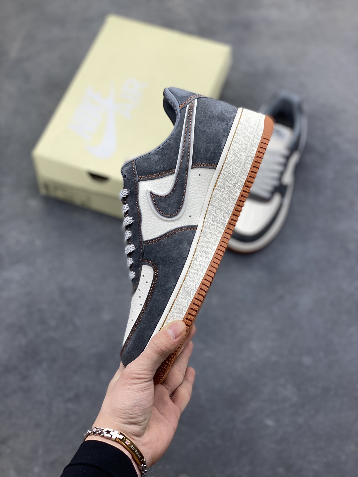 图片[3]-Nike Air Force 1 Low x The North Face 联名款｜硬核潮搭新标杆！当经典空军一号遇上户外王者北面，这双SS1979-005配色的Air Force 1 Low直接把街头潮流与户外机能风焊死在鞋面上！深灰磨砂麂皮碰撞米白皮革，橙棕车线勾勒出硬朗的户外质感，鞋侧双品牌标识强强联手，既有AF1的复古板鞋基因，又融入The North Face的户外硬核气场。生胶外底搭配Air气垫，踩屎感拉满的同时，复古氛围直接拉到顶点。不管是搭配工装裤走街头户外风，还是配牛仔裤搭休闲造型，这双鞋都能成为造型的点睛之笔，潮人鞋柜里的“王炸款”非它莫属！-选品中心