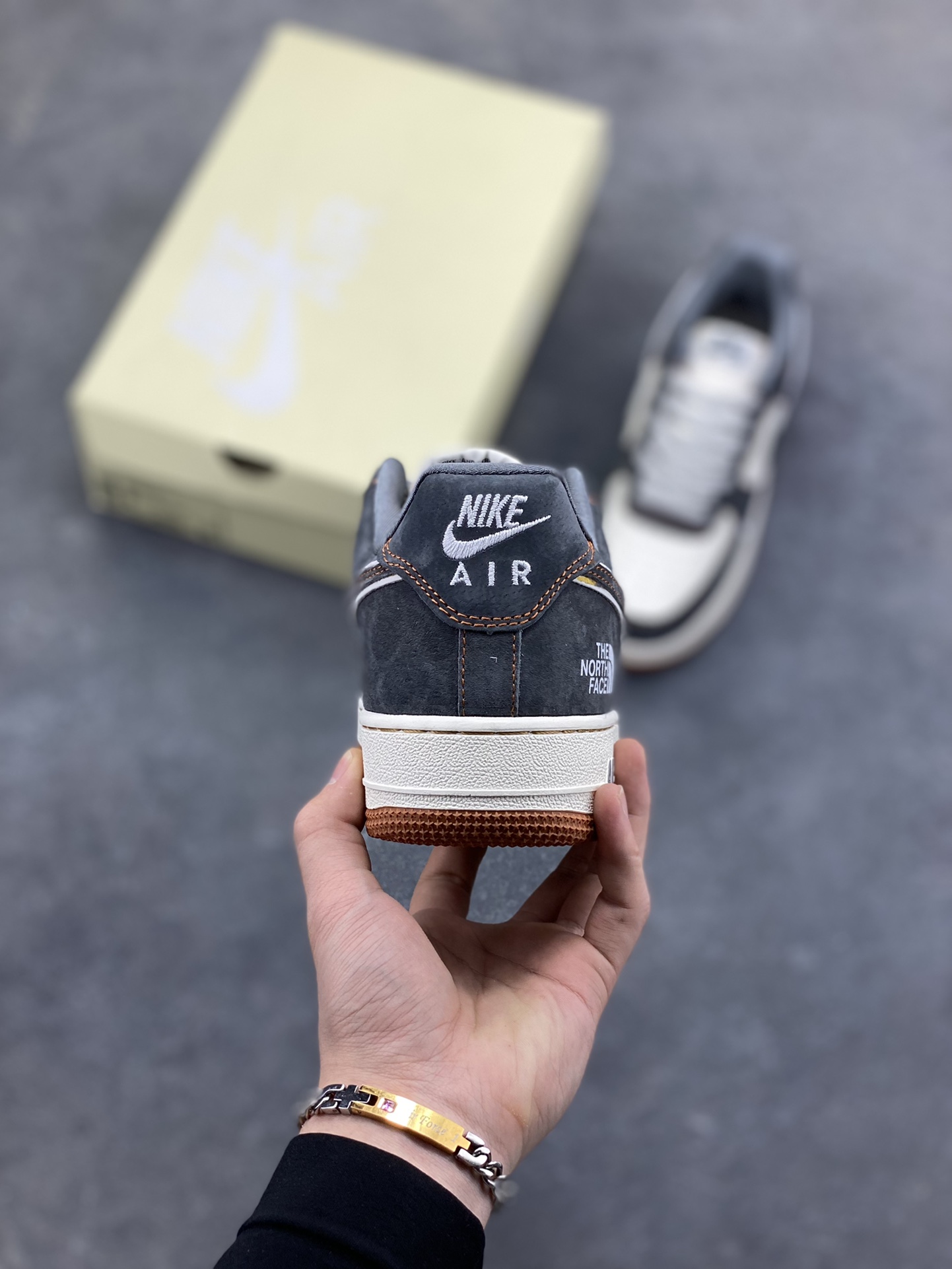 图片[4]-Nike Air Force 1 Low x The North Face 联名款｜硬核潮搭新标杆！当经典空军一号遇上户外王者北面，这双SS1979-005配色的Air Force 1 Low直接把街头潮流与户外机能风焊死在鞋面上！深灰磨砂麂皮碰撞米白皮革，橙棕车线勾勒出硬朗的户外质感，鞋侧双品牌标识强强联手，既有AF1的复古板鞋基因，又融入The North Face的户外硬核气场。生胶外底搭配Air气垫，踩屎感拉满的同时，复古氛围直接拉到顶点。不管是搭配工装裤走街头户外风，还是配牛仔裤搭休闲造型，这双鞋都能成为造型的点睛之笔，潮人鞋柜里的“王炸款”非它莫属！-选品中心