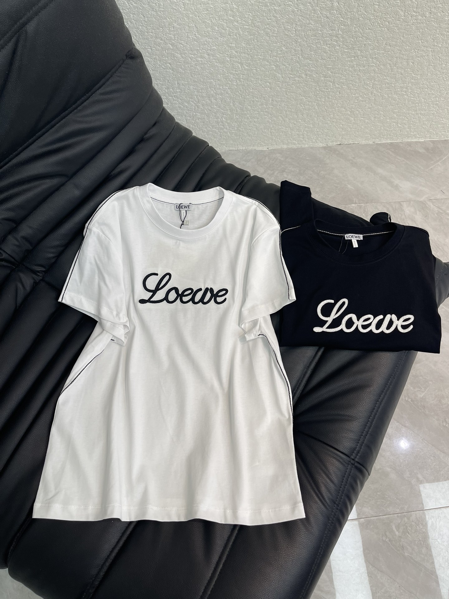 NO:666754,Loew*26 new spring and summer three-dimensional embroidered logo short-sleeved T-shirt. Customized YB native cotton material, breathable and comfortable, full of texture, regular short-sleeved T-shirt. The chest is processed with embroidery technology to outline the three-dimensional letter logo to strengthen the brand identity. The sides and sleeves of the clothes are hand-sewn with clear layers to create a fashionable style. Versatile black and white, choose at will. SML A,, loewe, T-shirt, tees, t-shirt,  19860909Loew*26春夏新款立体刺绣徽标短袖T恤.定制YB原生全棉材质,透气舒适,质感十足,常规短袖T恤,胸前利用刺绣工艺处理,勾勒出立体字母徽标,加强品牌标识度,衣服两侧与袖子手工缝制走线,层次分明,打造时尚风格,百搭黑白双色,随意选择.SML A,,loewe,T-shirt,tees，t-shirt, ,Women's clothing