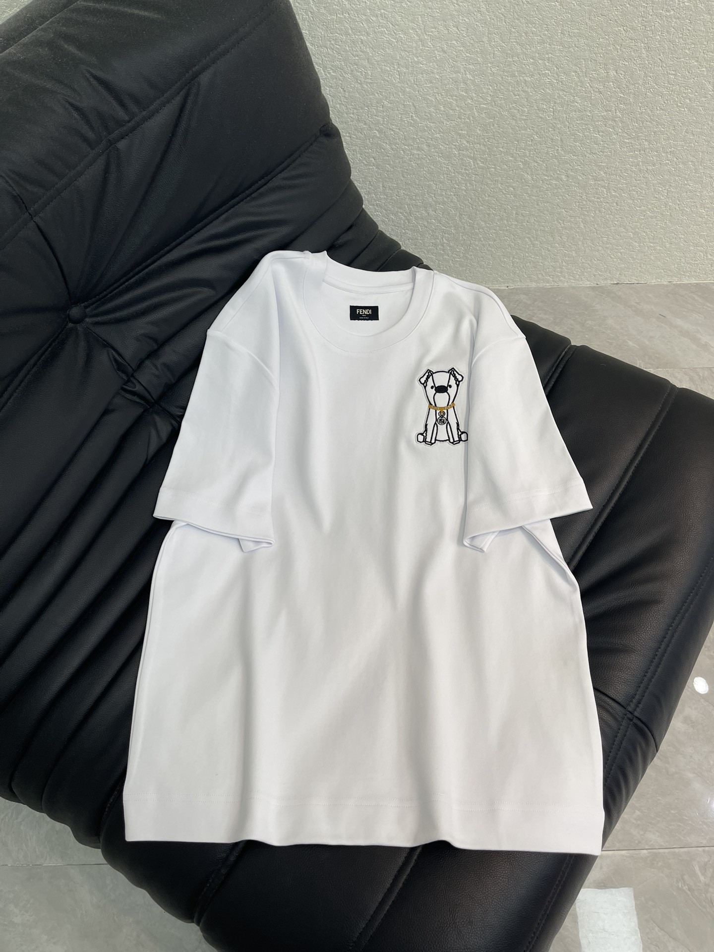 NO:666761,Fend*26 new spring and summer round neck embroidered puppy logo short-sleeved T-shirt. Customized YB native cotton material, fine texture, comfortable and breathable, loose short-sleeved cutting, highlighting the brand style. Made of native cotton material, high-grade glossy texture, embroidery process restores the cute puppy pattern sitting on the chest, golden collar double F logo highlights the brand style, refreshing and age-reducing, loose fit, relaxed and fashionable. SML  A,,fendi,T-shirt,tees,t-shirt, 19860909Fend*26春夏新款圆领刺绣小狗徽标短袖T恤.定制YB原生全棉材质,质感细腻,舒适透气,宽松短袖裁剪,凸显品牌格调,采用原生全棉材质,质感高级光泽,刺绣工艺还原胸前坐姿可爱小狗图案,金色项圈双F徽标凸显品牌格调,清爽减龄,宽松版型,穿搭松弛时尚.SML A,,fendi,T-shirt,tees，t-shirt, ,Women's clothing