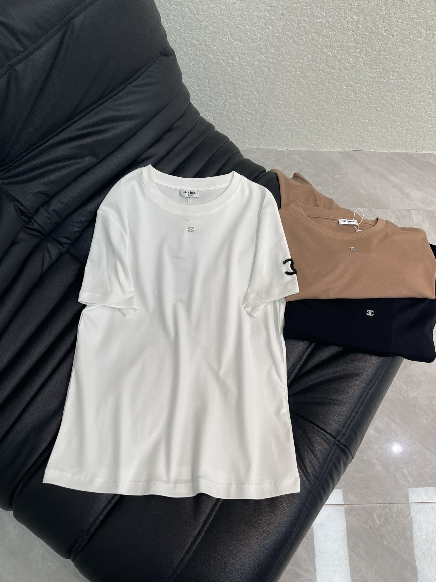 NO:666770,Chane*26 new spring and summer round neck beaded logo short-sleeved T-shirt. Customized YB mercerized cotton material, fine texture, comfortable and breathable, regular short-sleeved T-shirt cutting, beading process to restore the three-dimensional double C logo pattern on the outside of the arm cuff, light refraction luxury, echoing the rhinestone double C on the front of the collar, highlighting the brand style, regular version, wearing slim and fashionable. SML A,,chanel,T-shirt,tees,t-shirt, 19860909Chane*26春夏新款圆领钉珠徽标短袖T恤.定制YB丝光全棉材质,质感细腻,舒适透气,常规短袖T恤裁剪,钉珠工艺还原单侧手臂袖口外侧的立体双C徽标图案,光线折射奢华满分,呼应领前水钻双C,凸显品牌格调,常规版型,穿搭显瘦时尚.SML A,,chanel,T-shirt,tees，t-shirt, ,Women's clothing