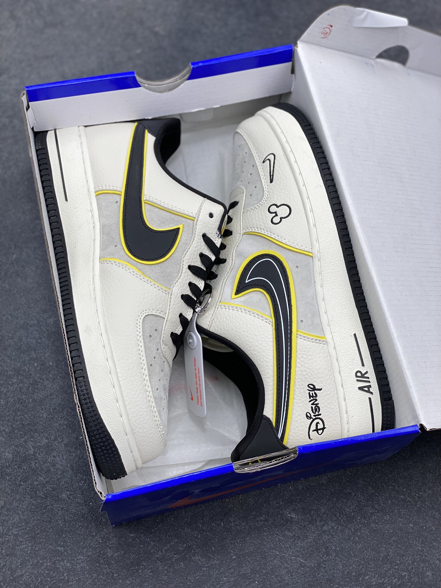 图片[9]-童趣奢潮碰撞！AF1 Low x Disney 联名款唤醒童年DNA 当Nike Air Force 1 Low的经典街头骨架遇上迪士尼的童话基因，这双SY1388-021联名款直接把「潮玩童趣」焊在了鞋面上！ 鞋身以奶白荔枝纹皮革搭配浅灰磨砂皮打造基底，黑黄撞色的Swoosh线条利落又俏皮，黄色包边如漫画描边般勾勒出灵动质感。鞋头的米奇轮廓简笔画、鞋侧的Disney手写体标识，将迪士尼的经典元素以手绘风呈现，细节处满是童真巧思；黑白撞色鞋带搭配经典AF1中底的「AIR」标识，保留了空军一号的街头底蕴，让童趣与潮流实现完美平衡。 作为AF1与迪士尼的跨界联名，这双鞋既延续了Air Force 1 Low的百搭属性，又凭借迪士尼的IP加持成为吸睛利器。不管是日常出街打造甜酷造型，还是作为迪士尼粉丝的收藏款，这双AF1 Low x Disney联名款都能让你在潮流圈玩转出独特的童趣风格，属于大人的童话潮鞋，入手即解锁双倍快乐！-选品中心