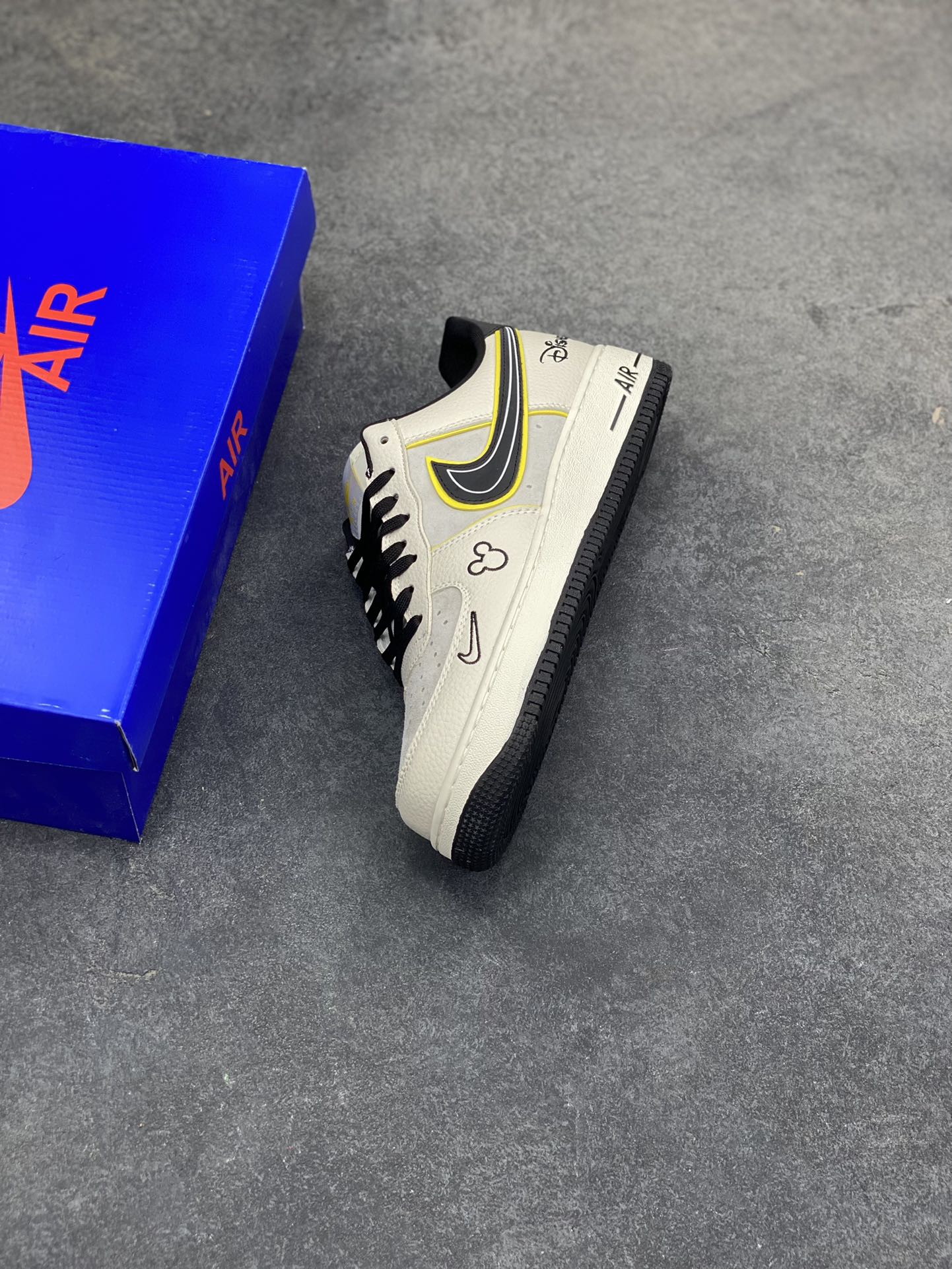 图片[7]-童趣奢潮碰撞！AF1 Low x Disney 联名款唤醒童年DNA 当Nike Air Force 1 Low的经典街头骨架遇上迪士尼的童话基因，这双SY1388-021联名款直接把「潮玩童趣」焊在了鞋面上！ 鞋身以奶白荔枝纹皮革搭配浅灰磨砂皮打造基底，黑黄撞色的Swoosh线条利落又俏皮，黄色包边如漫画描边般勾勒出灵动质感。鞋头的米奇轮廓简笔画、鞋侧的Disney手写体标识，将迪士尼的经典元素以手绘风呈现，细节处满是童真巧思；黑白撞色鞋带搭配经典AF1中底的「AIR」标识，保留了空军一号的街头底蕴，让童趣与潮流实现完美平衡。 作为AF1与迪士尼的跨界联名，这双鞋既延续了Air Force 1 Low的百搭属性，又凭借迪士尼的IP加持成为吸睛利器。不管是日常出街打造甜酷造型，还是作为迪士尼粉丝的收藏款，这双AF1 Low x Disney联名款都能让你在潮流圈玩转出独特的童趣风格，属于大人的童话潮鞋，入手即解锁双倍快乐！-选品中心