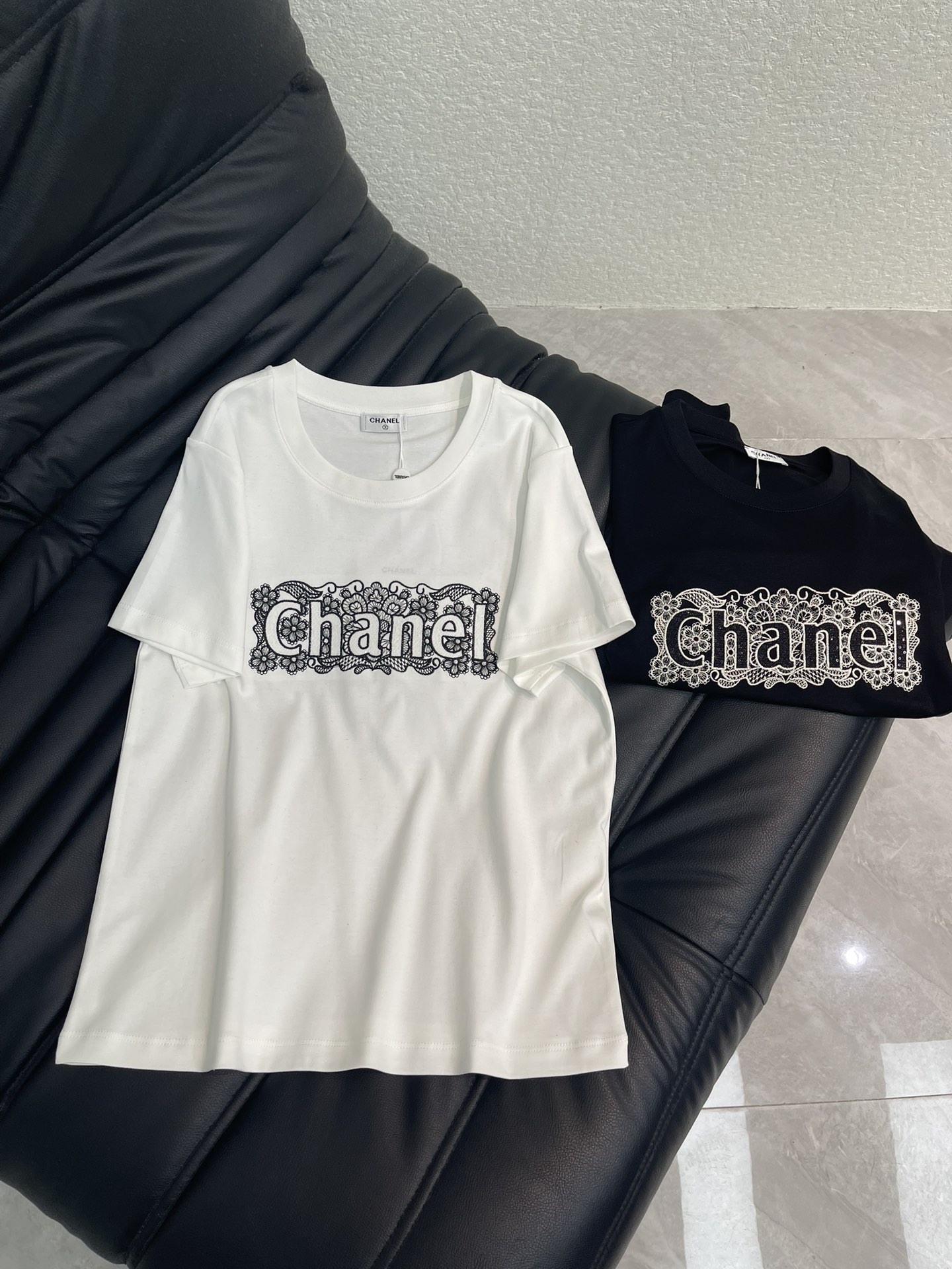 NO:667588,Chane*26 new spring and summer lace embroidered logo short-sleeved T-shirt. Customized YB mercerized cotton material, breathable and comfortable, full of texture. Regular short-sleeved T-shirt. The chest is processed with embroidery technology to outline the three-dimensional letter logo. The bottom layer is made of hollow lace texture to create flowers and leaves.  Natural patterns, full of soft temperament, while enhancing recognition, clear layers, creating temperament and style, versatile black and white, choose at will. SML, chanel, T-shirt, tees, t-shirt, alexander  wang19860909Chane*26春夏新款蕾丝刺绣徽标短袖T恤.定制YB丝光全棉材质,透气舒适,质感十足,常规短袖T恤,胸前利用刺绣工艺处理,勾勒出立体字母徽标,底层以镂空蕾丝肌理打造花叶自然图案,充满柔美气质,同时加强辨识度,层次分明,打造气质风格,百搭黑白双色,随意选择.SML,,chanel,T-shirt,tees，t-shirt, ,Women's clothing