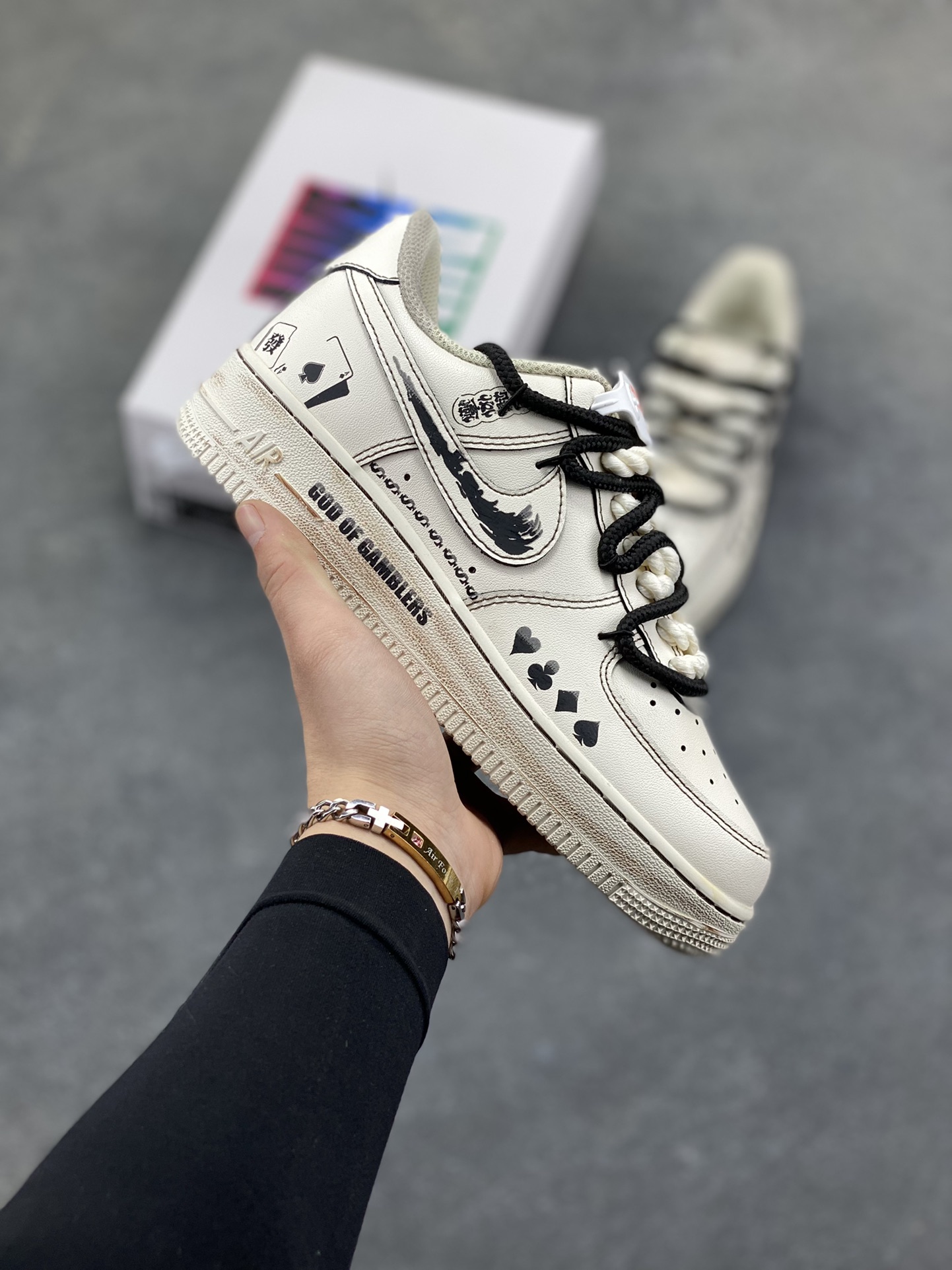 手绘涂鸦“赌神底牌”Nike Air Force 1 “GOD OF GAMBLERS”空军一号定制板鞋 米白基底像未掀开的牌面，黑调涂鸦勾勒出扑克牌花色、“GOD OF GAMBLERS” 字样，搭配黑白绳结鞋带，自带复古港风的凌厉气场；做旧质感与手绘笔触交织，让每一处设计都像藏着 “底牌” 的惊喜，是把 “赌局氛围感” 穿在脚上的潮酷单品 货号：315122-313 尺码： 36 36.5 37.5 38 38.5 39 40 40.5 41 42 42.5 43 44 44.5 45-选品中心