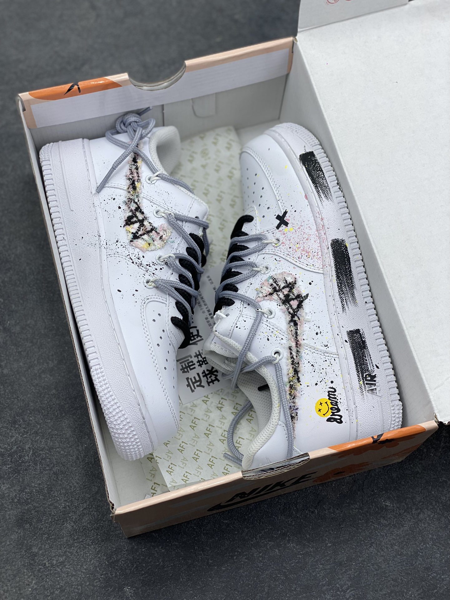 图片[9]-订制空军一号板鞋 该定制版球鞋选用原鞋款为Nike Air Force 1‘07空军一号，身铺满黑白泼墨+手绘纹理，混着细碎彩点，像随手挥洒的街头手稿；鞋侧贴了笑脸标+手写字样，再加上一块“毛边破缝”的拼接料，甜感里掺了点废土风的随性；连鞋带都用了黑白撞色，中底也加了黑线条点缀，细节里全是“不撞款”的小心思。 货号：DH1999-334 尺码： 36 36.5 37.5 38 38.5 39 40 40.5 41 42 42.5 43 44 44.5 45-选品中心